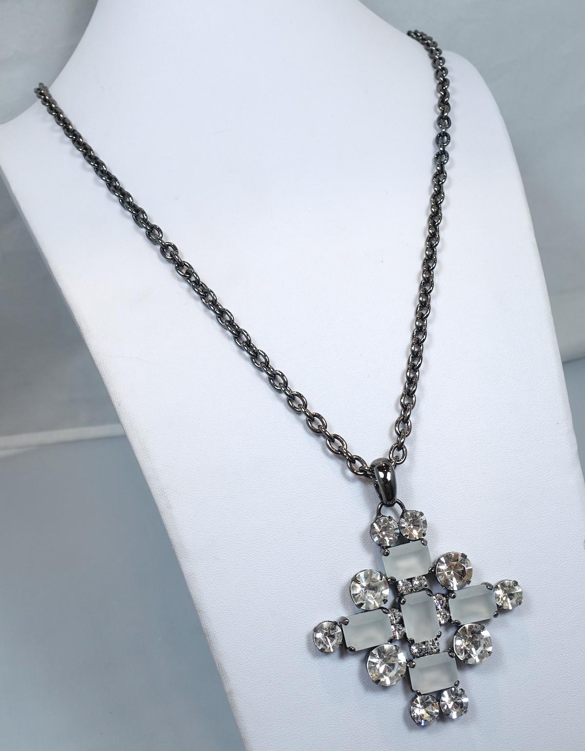 This signed Kenneth Jay Lane necklace features a maltese cross design with smoky & clear crystals in a gun metal setting.  The link chain measures 28” x ¼”; the pendant is 2-1/2” x 2-1/2”.  In excellent condition, this pendant necklace is signed