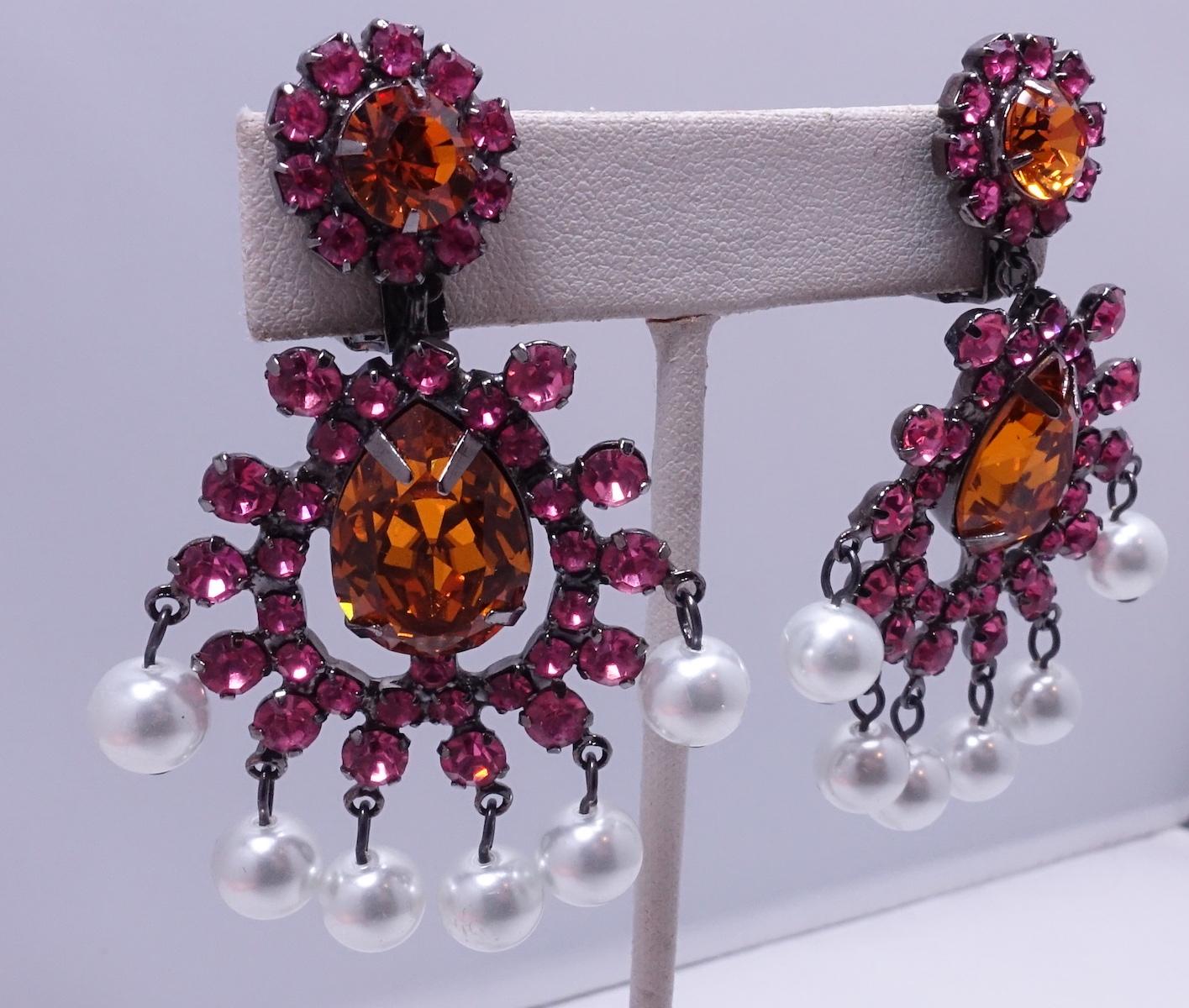 These signed Kenneth Lane earrings feature faux pearls with pink & citrine crystal accents in a japanned silvertone setting.  In excellent condition, these clip earrings measure 2-1/2” x 1-3/4” and are signed “Kenneth Lane”.