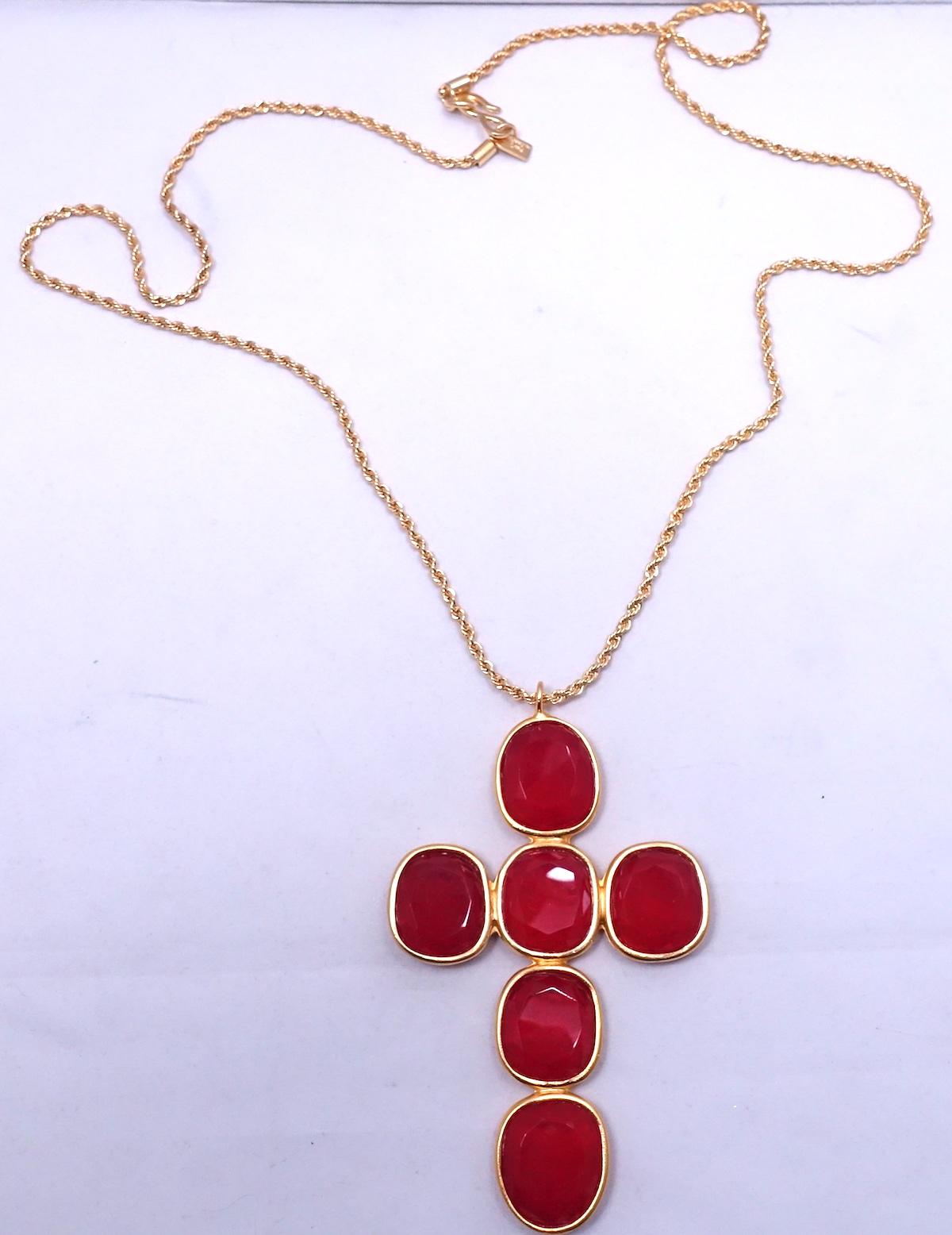 This signed Kenneth Lane necklace features a red Lucite cross in a gold tone setting.  The pendant measures 4-1/2” x 2-3/4”; the rope chain is 32” x 1/8” with a hook closure.  In excellent condition, this pendant necklace is signed “Kenneth Lane”.