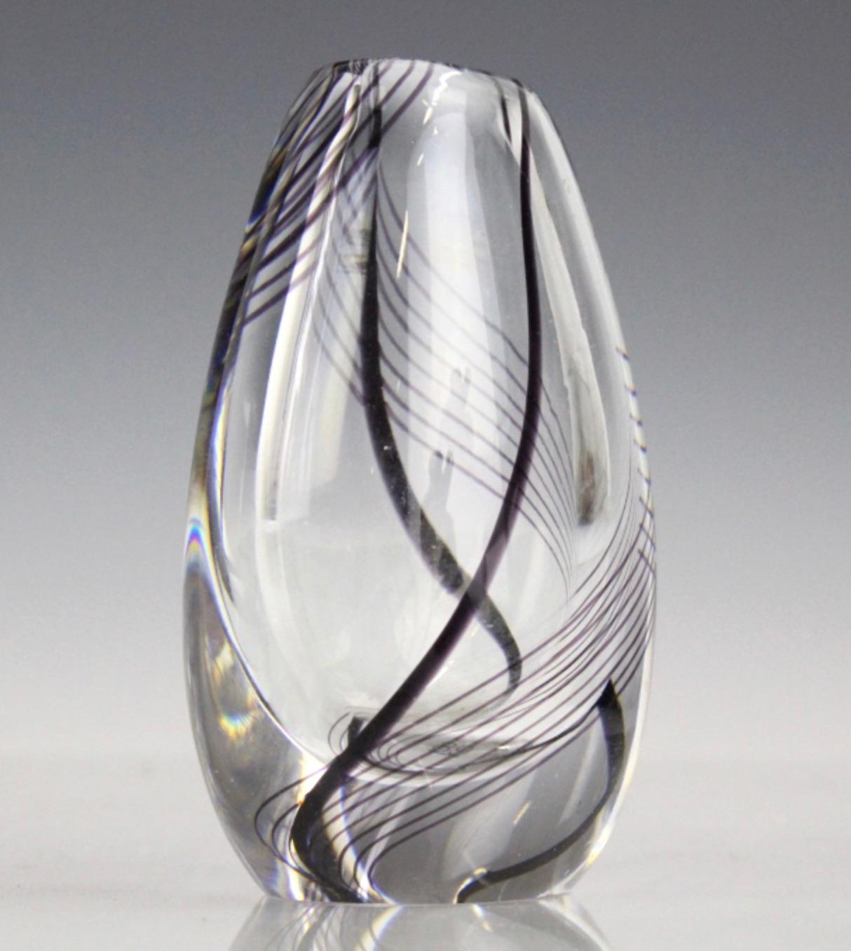 Exceptional heavy thick art glass vase fabricated by Kosta Boda, Sweden, circa 1960. This vase was designed and signed by Vicke Lindstrand. The vase is clear cased glass with a poetic design of black and purple swirling lines.
Signed on base Kosta
