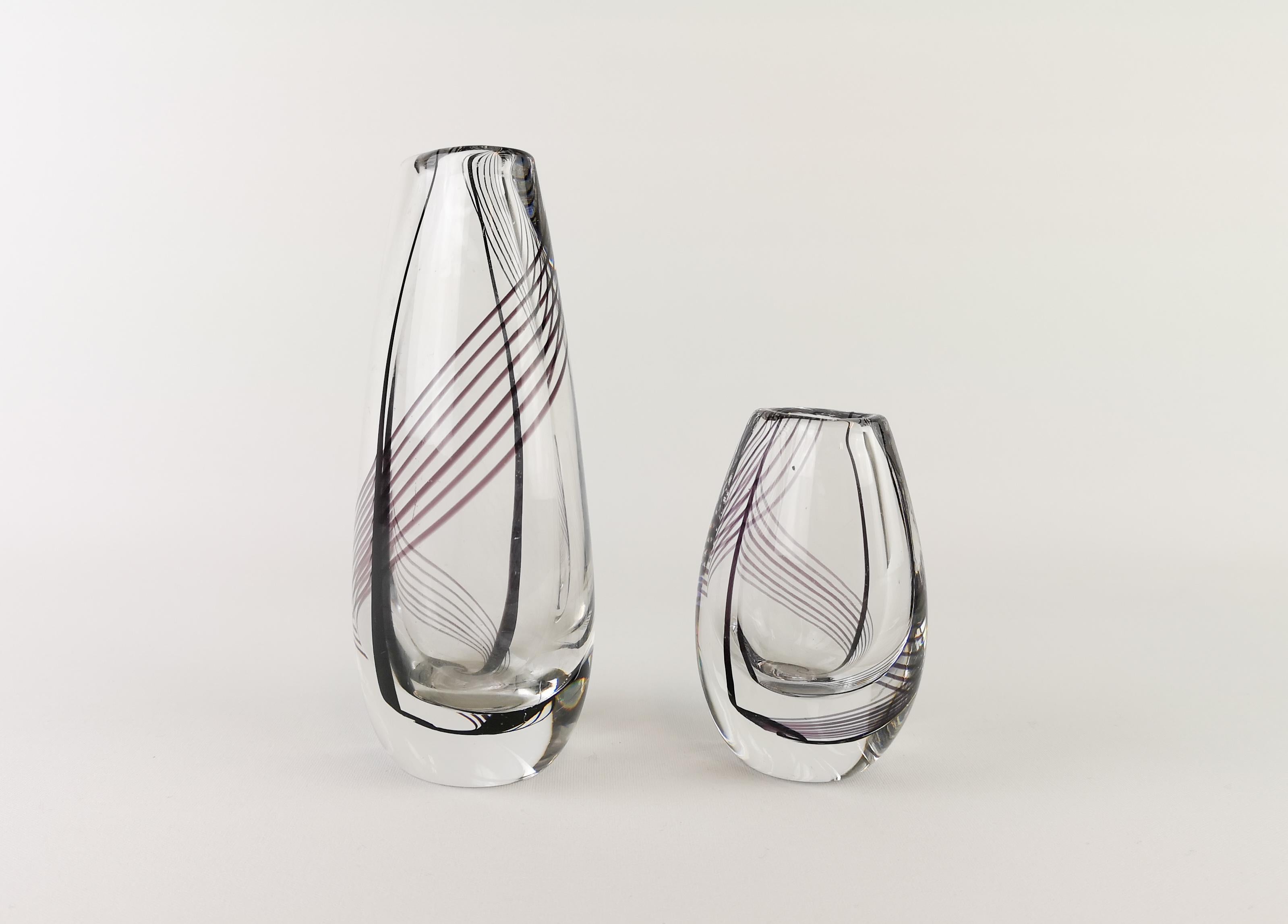 Exceptional heavy thick art glass vases fabricated by Kosta Boda, Sweden, 1959. These vases was designed and signed by Vicke Lindstrand. The vases is clear cased glass with a nice pattern of black and purple swirling lines.
The small one signed on