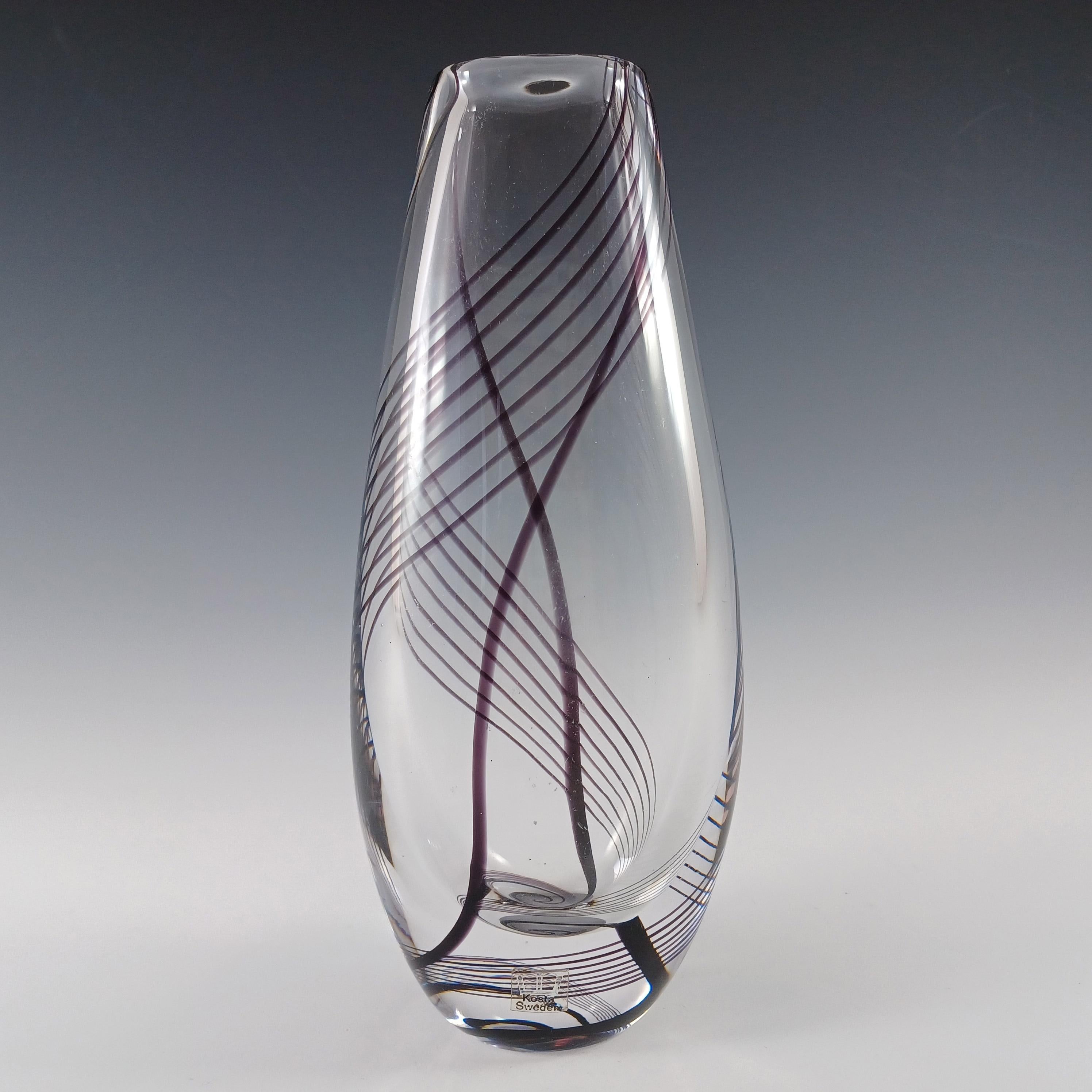 Impresionante jarrón escandinavo de cristal transparente, alto y pesado (1,4 kg sin envasar), con motivos de hilos de color morado oscuro, fabricado por Kosta Boda de Suecia y diseñado por Vicke Lindstrand. Firmado en la base: 