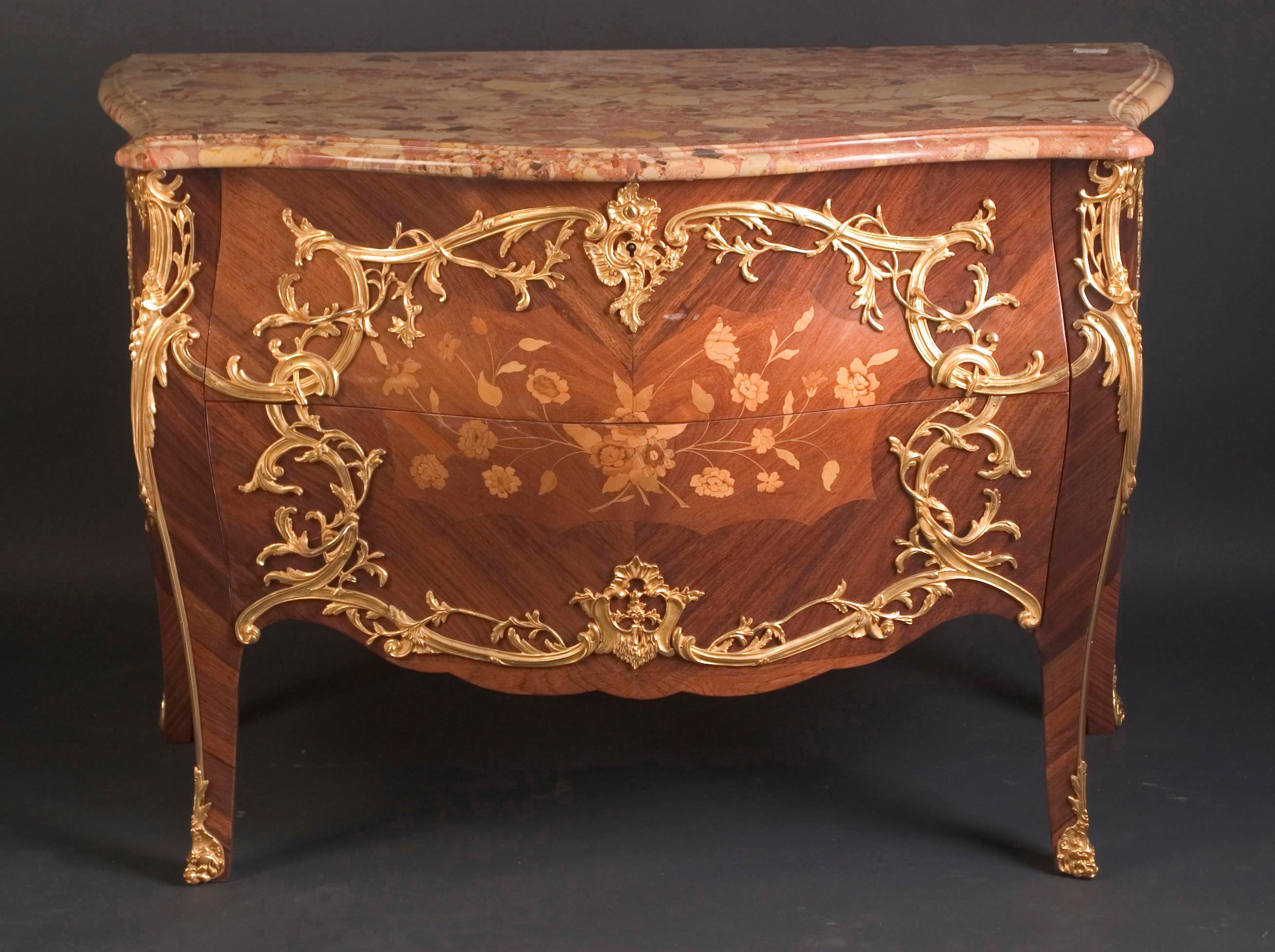 This fantastic Louis XV two drawer Bombé commode features finely chased bronze d’ore mounts in the floriate manner throughout. The French antique piece dates back to the 19th century, circa 1880, and is signed by the artisan “Krieger,” well known