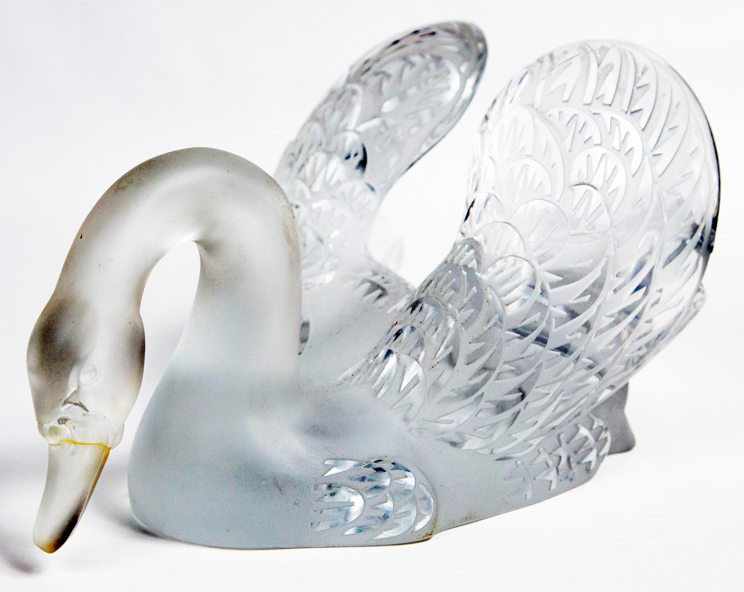 Frosted and clear crystal of a swan with head down, wings proudly displayed.
Signed Lalique Paris in script on the bottom edge of the tail. shown in photo 9 just above the dark cloth placed so that it is more visible. The signature is on the curve