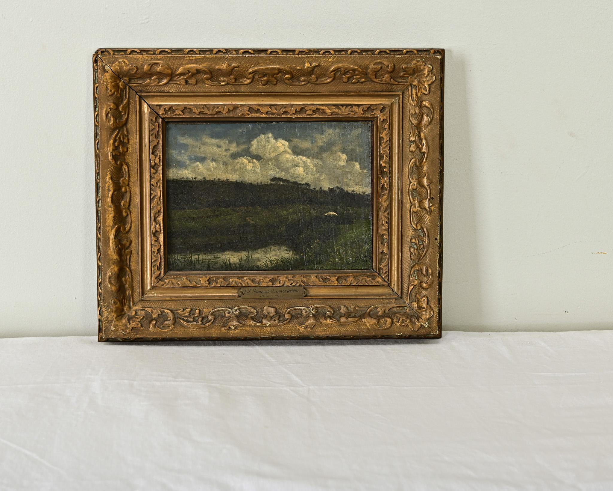 Meraviglioso paesaggio su tavola firmato e datato dell'artista belga Jean-Francois Pierre Lamoriniere, che raffigura un tranquillo stagno tra dolci colline sotto un cielo drammatico di nuvole soffocanti. La cornice ornata, intagliata e dorata,