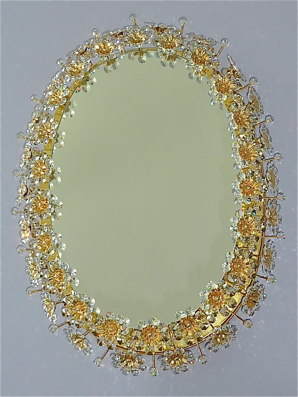 Signed large oval gilt brass metal crystal glass backlit wall mirror made by Palwa, Germany, circa 1960-1970, documented in the Palwa sales catalog and signed at the back with Palwa company label with model number. The frame has lots of beautiful