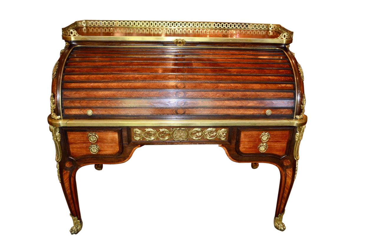 The finest quality Louis XV/XVI transitional style gilt bronze mounted tulipwood and amaranth cylinder desk by L. Cueunieres after models by Jean-Francois Oeben (French 1721-1763). The underside is stamped four times L. Cueunieres Jne Ebieniste,