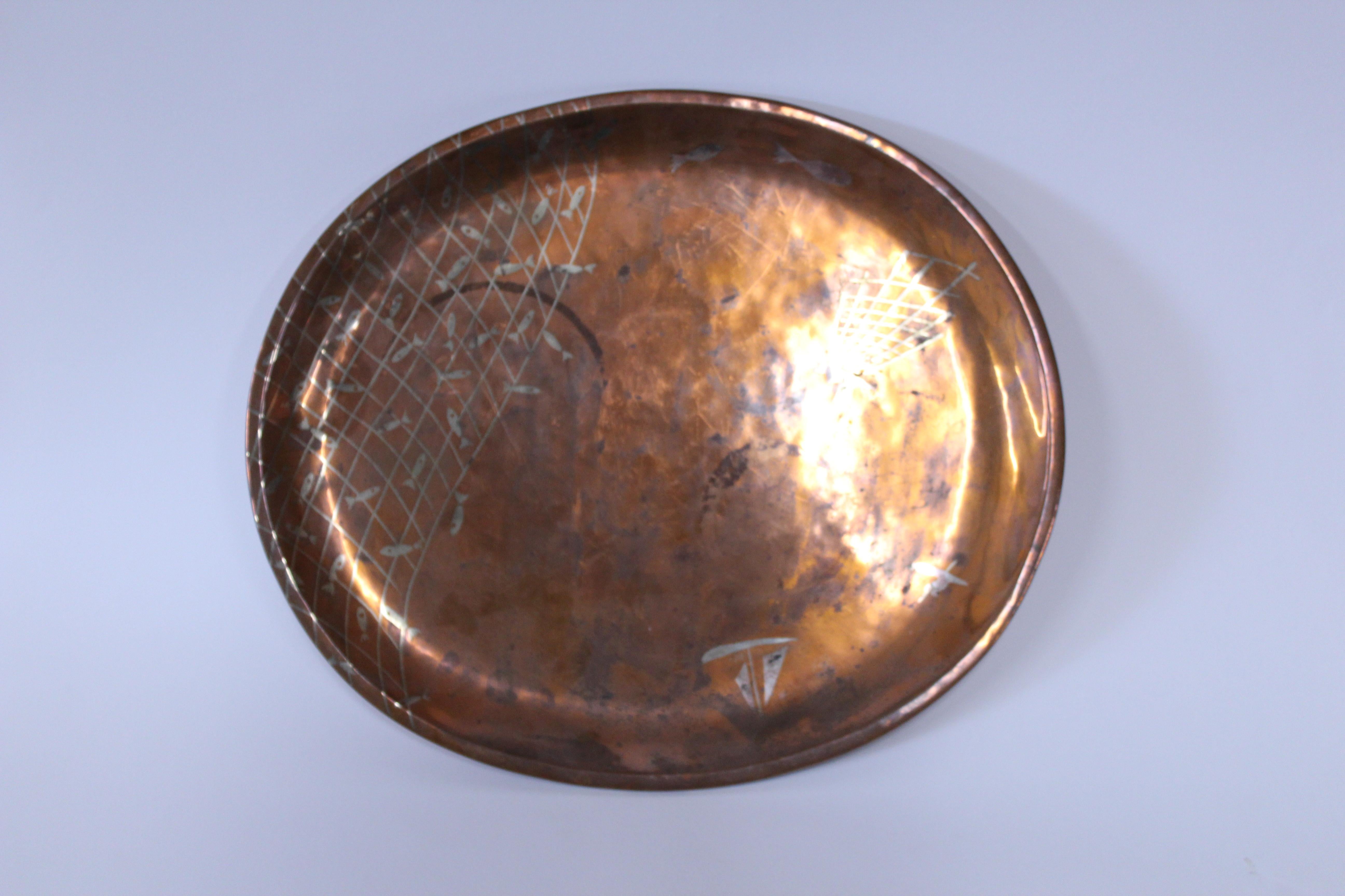 Los Castillo hallmarked round serving tray of copper/mixed metals with abstract boat and fishing net design from the 1950s.
