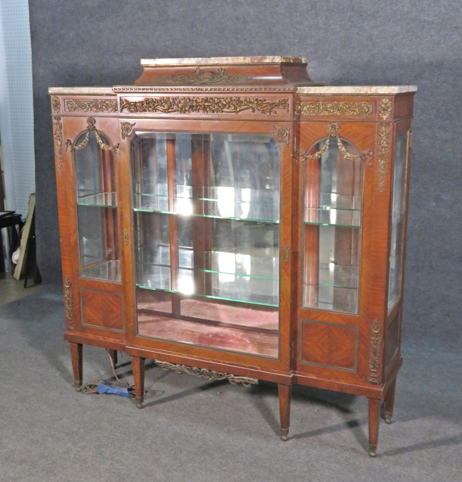 Signed. Brass ormolu. Marble top. One glass door containing 2 glass shelves. Measures: Lighted. 54 3/8