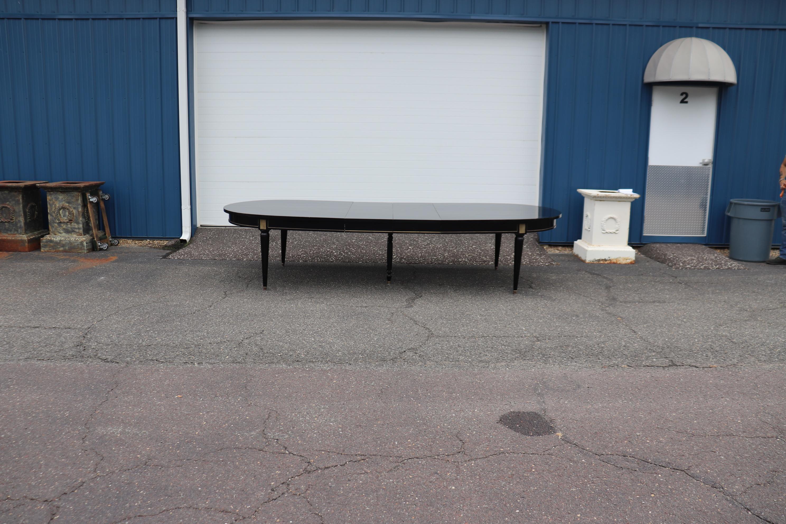 This is a fantastic and gorgeous signed Maison Jansen ebonized lacquer dining table. The table is designed in the Directoire manner and is in good condition with minimal signs of age and use and will show moderate wear and we will polish and
