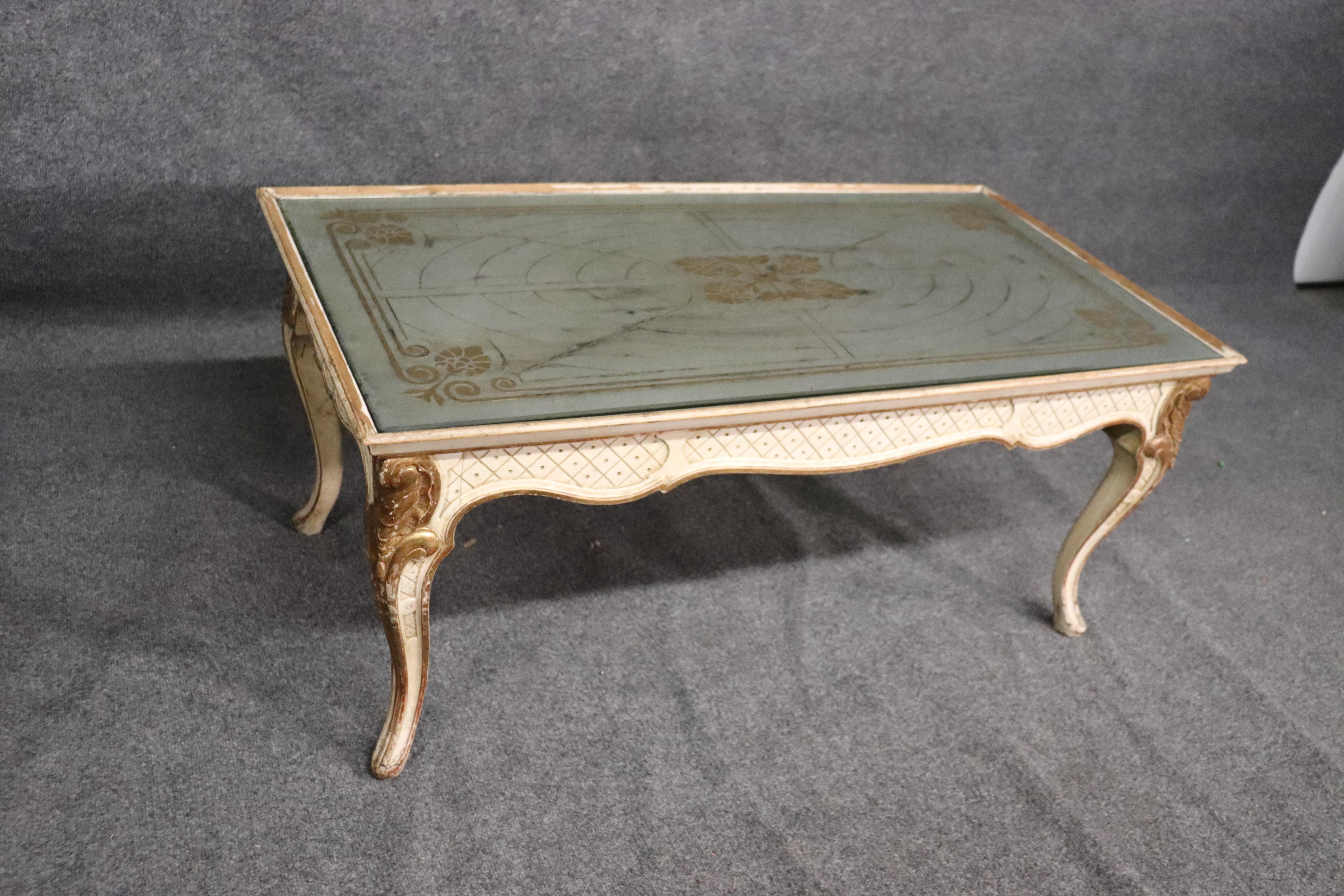 This is a gorgeous Maison Jansen coffee table that has an original gold and silver eglomise top. The table is designed in the Louis XV manner and is in good condition with the emobossed Jansen stamp. Dates to the 1950s era. Measures 41 wide x 22