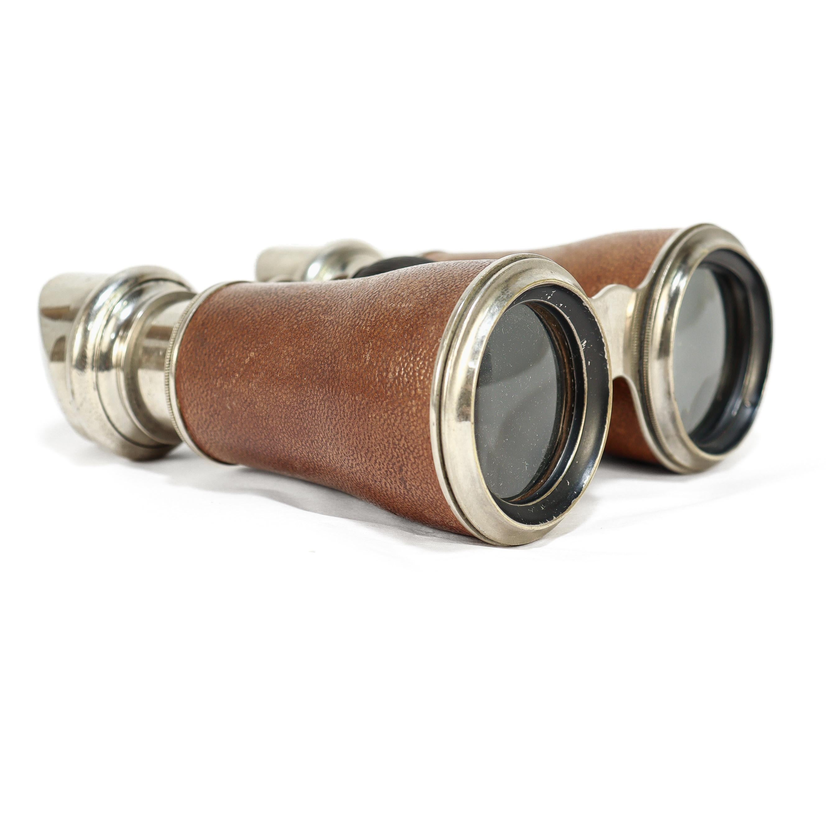 Un elegante binocolo antico. 

Dalla Marchesa di Parigi.

Con un ingrandimento relativamente basso, ottone cromato, coppe oculari ricurve e coperture in pelle.

Mantiene l'ottica funzionale e la ruota di messa a fuoco.

Semplicemente un bel binocolo