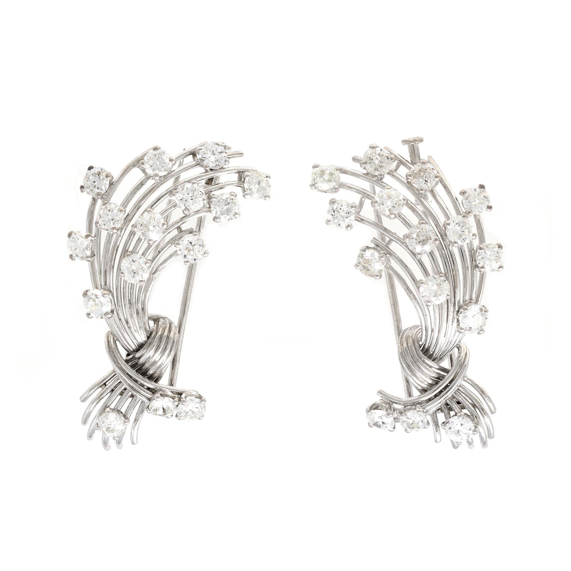 A vintage pair of clips signed by the iconic French house of MAUBOUSSIN Paris. The open work clips circa 1950 are set in platinum with the pin attachments in 18 karat white gold. The estimated weight of the diamonds is 7.50 carats of G color and