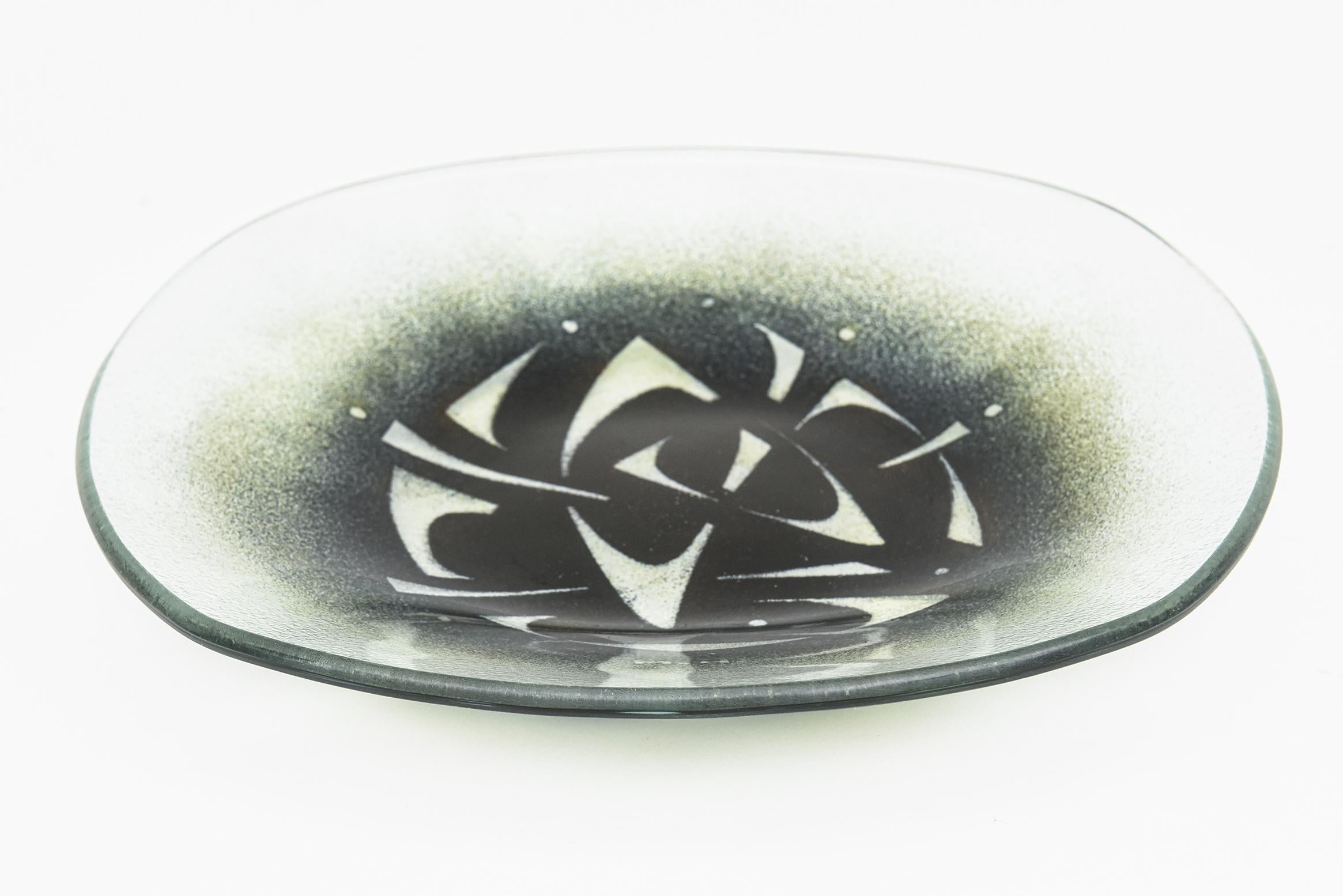 This most unusual signed glass bowl or plate by Maurice Heaton is vintage and from the 60's. The pattern and color of abstractions of green against black with white are a stand out.
The rest of the bowl is transparent and clear with a hint of