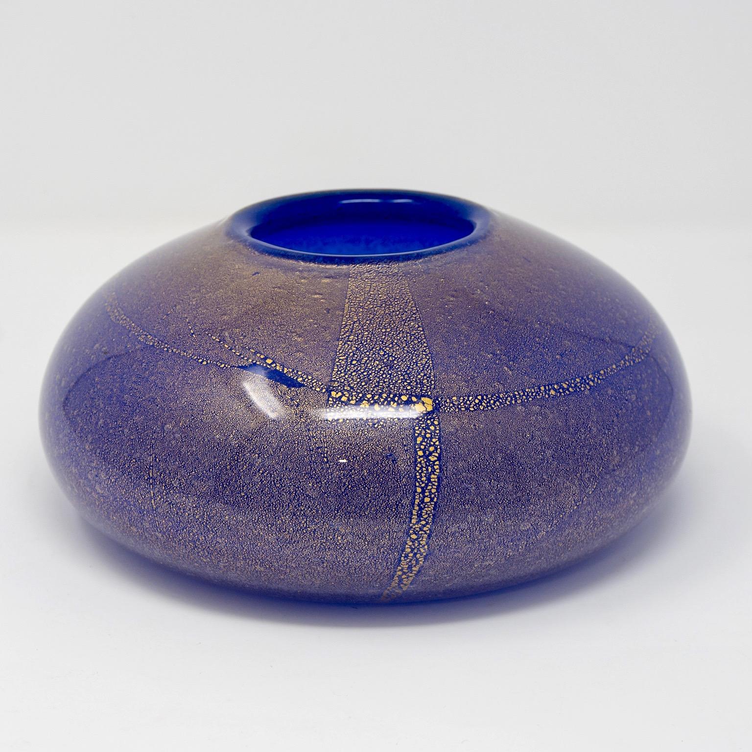 Cenedese low and wide round vase in cobalt blue Murano glass with gold inclusions, circa 1970s. Original label still affixed. Etched maker’s mark on underside of base. No flaws found.
    