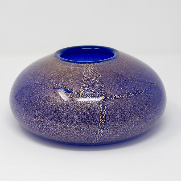 Cenedese low and wide round vase in cobalt blue Murano glass with gold inclusions, circa 1970s. Original label still affixed. Etched maker’s mark on underside of base. No flaws found.
    