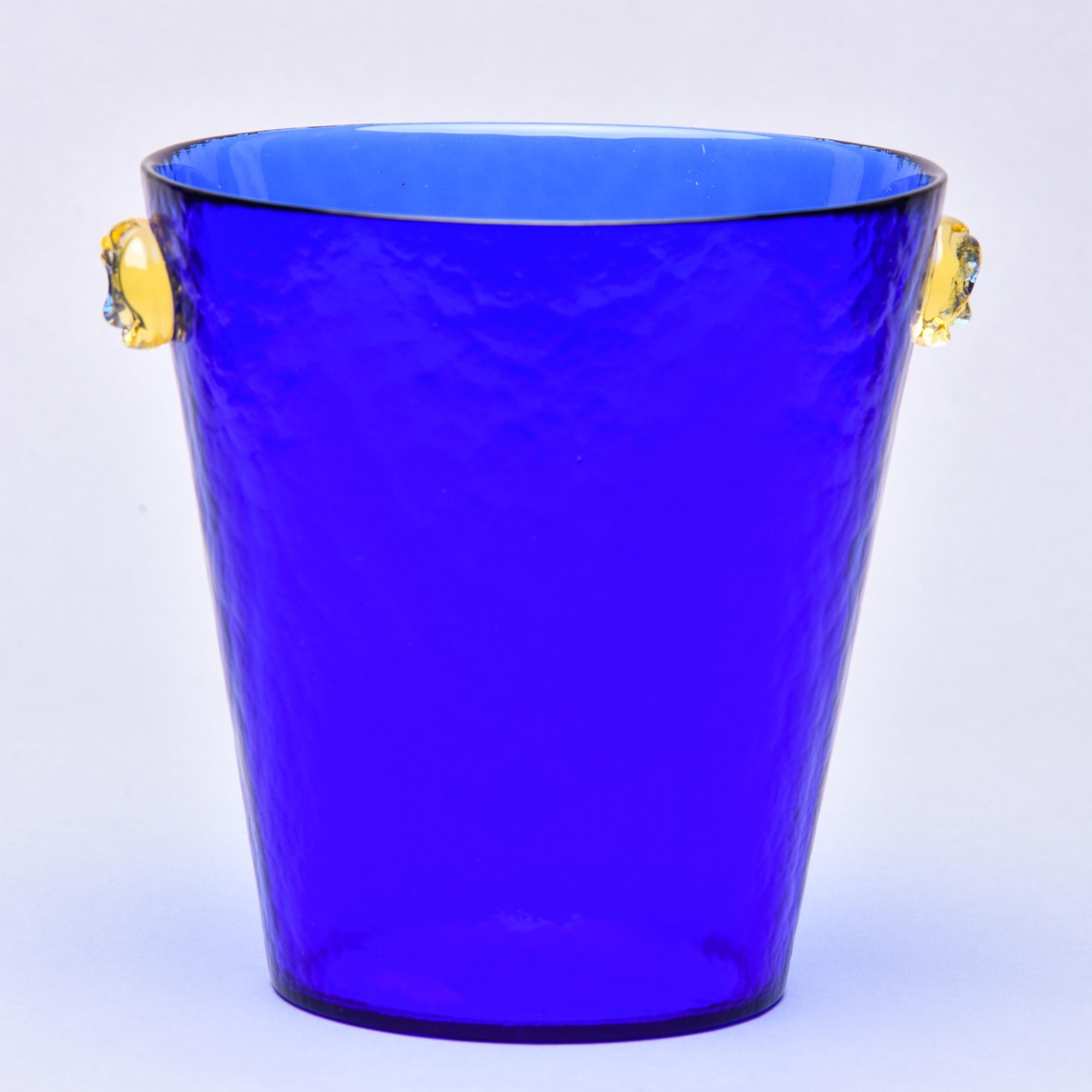 Found in Italy, this circa 1960s Murano glass ice bucket or wine cooler in deep blue has contrasting gold handles at the sides. Acid etched maker’s mark on underside of base: Ca dei Vetrai Murano. No flaws found. Two available at the time of this