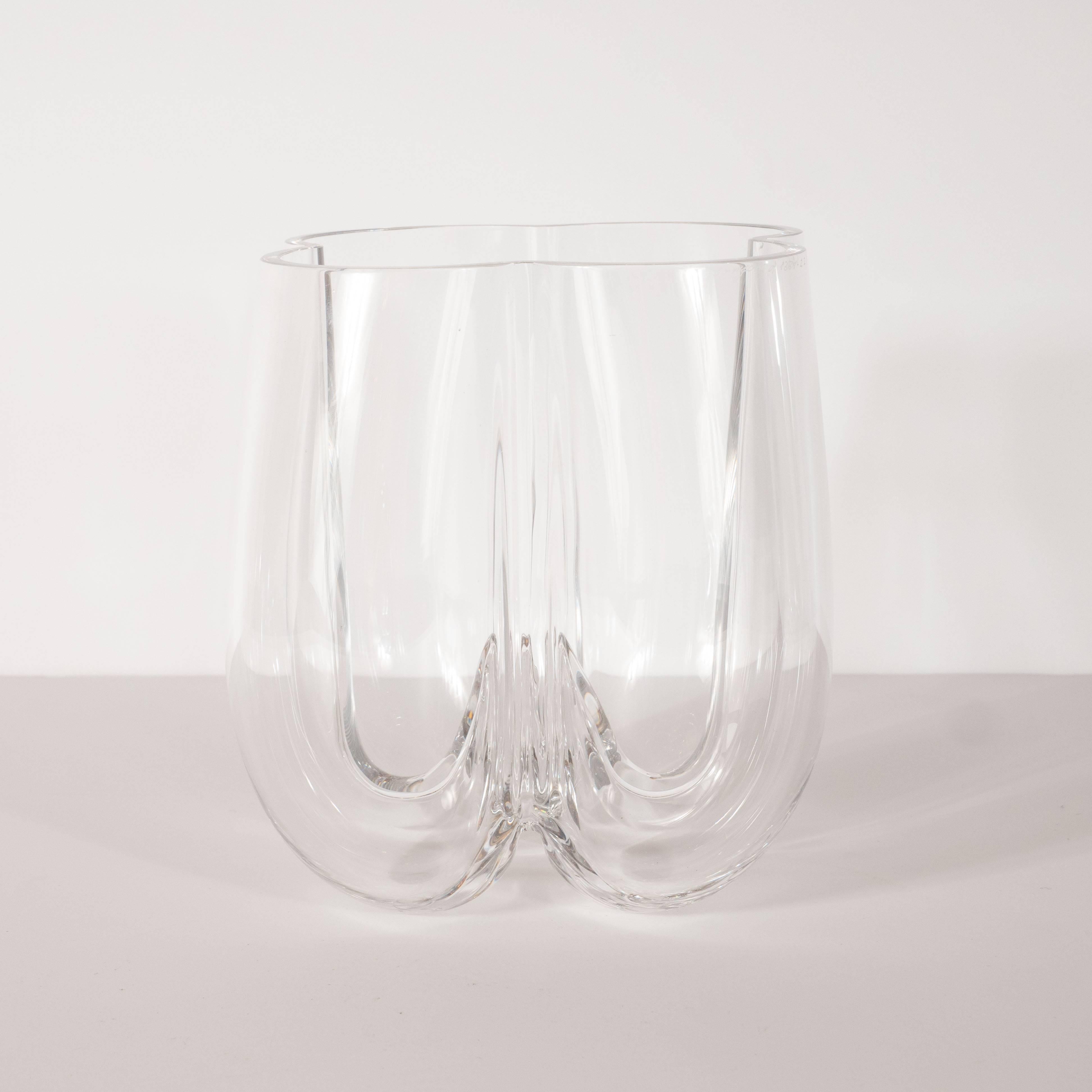 This sophisticated and striking vase was handblown by the esteemed Swedish glass studio, Orrefors, circa 1960. It features four adjoining curvilinear lobes separated by channel detailing that converge in the centre to form a stalagmite like