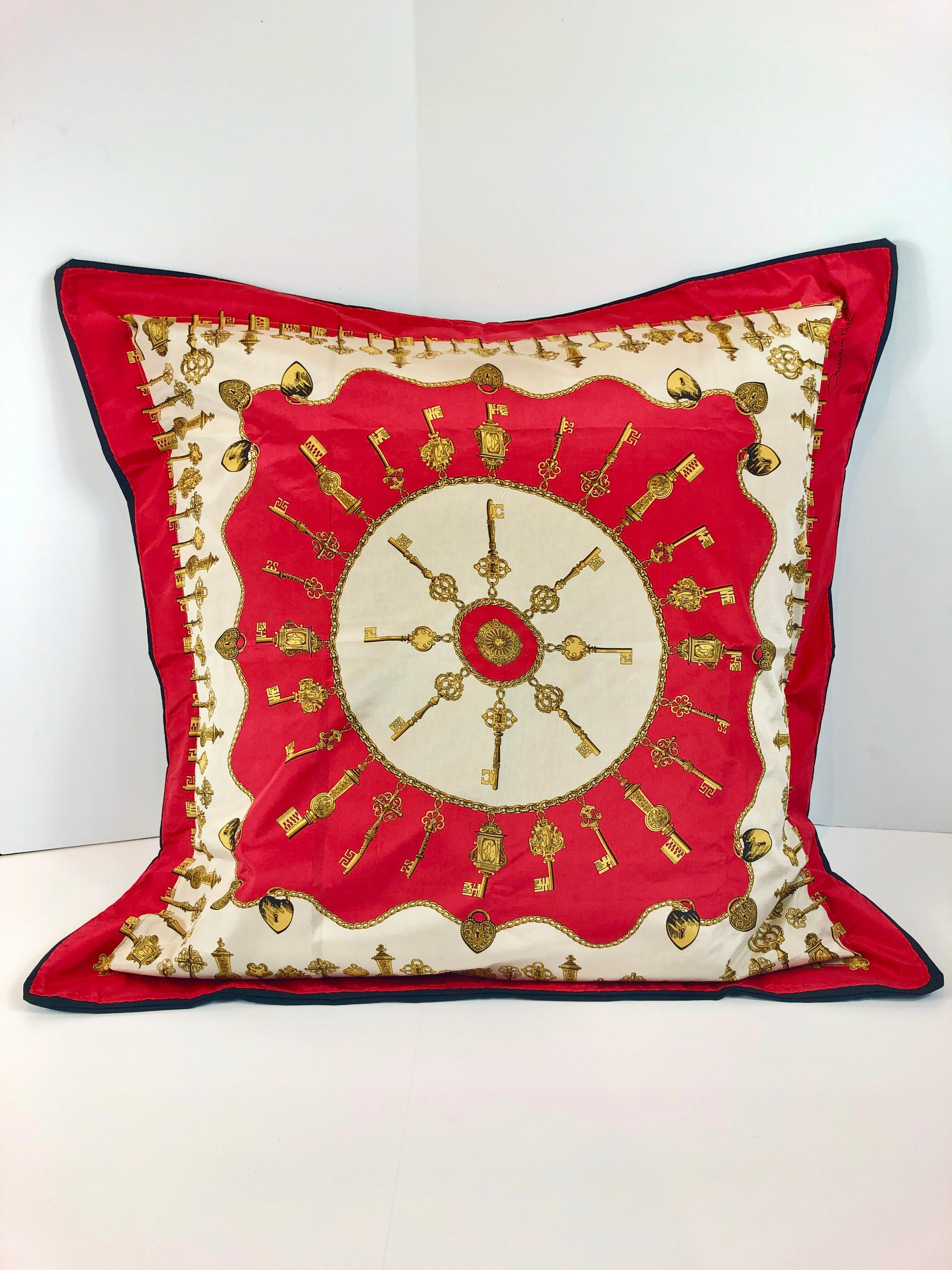 Offered is a Mid-Century Modern signed Oscar De La Renta red, white, gold and black silk scarf upholstered in a black cotton percale with a 28 x 28 filler decorative pillow. The scarf has a cherry red background with a gold antique key design. This