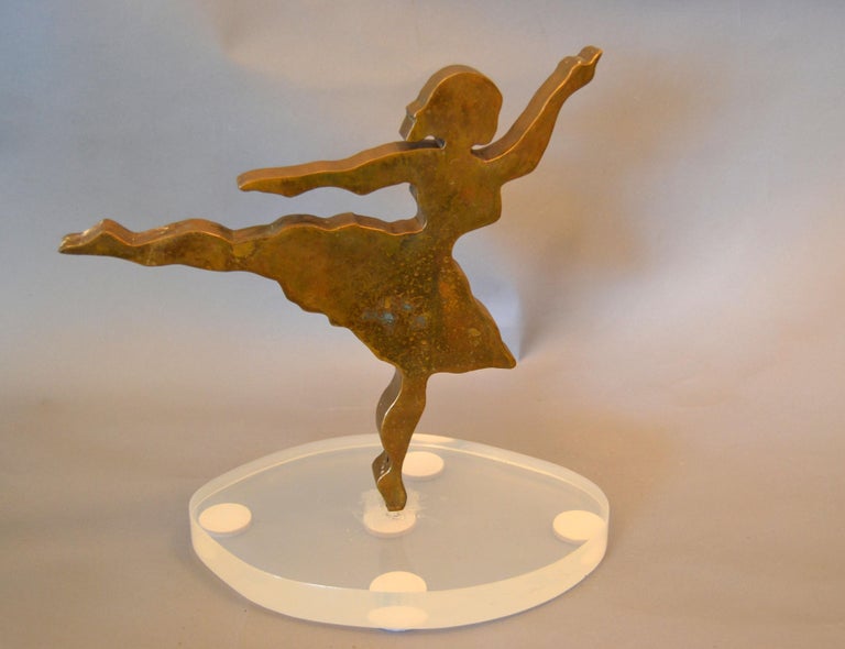 Signed Mid-Century Modern solid bronze ballerina dancer sculpture on an oval Lucite base.
Dated 1975 and signed by the Artist. 
Simply a graceful table sculpture.

     