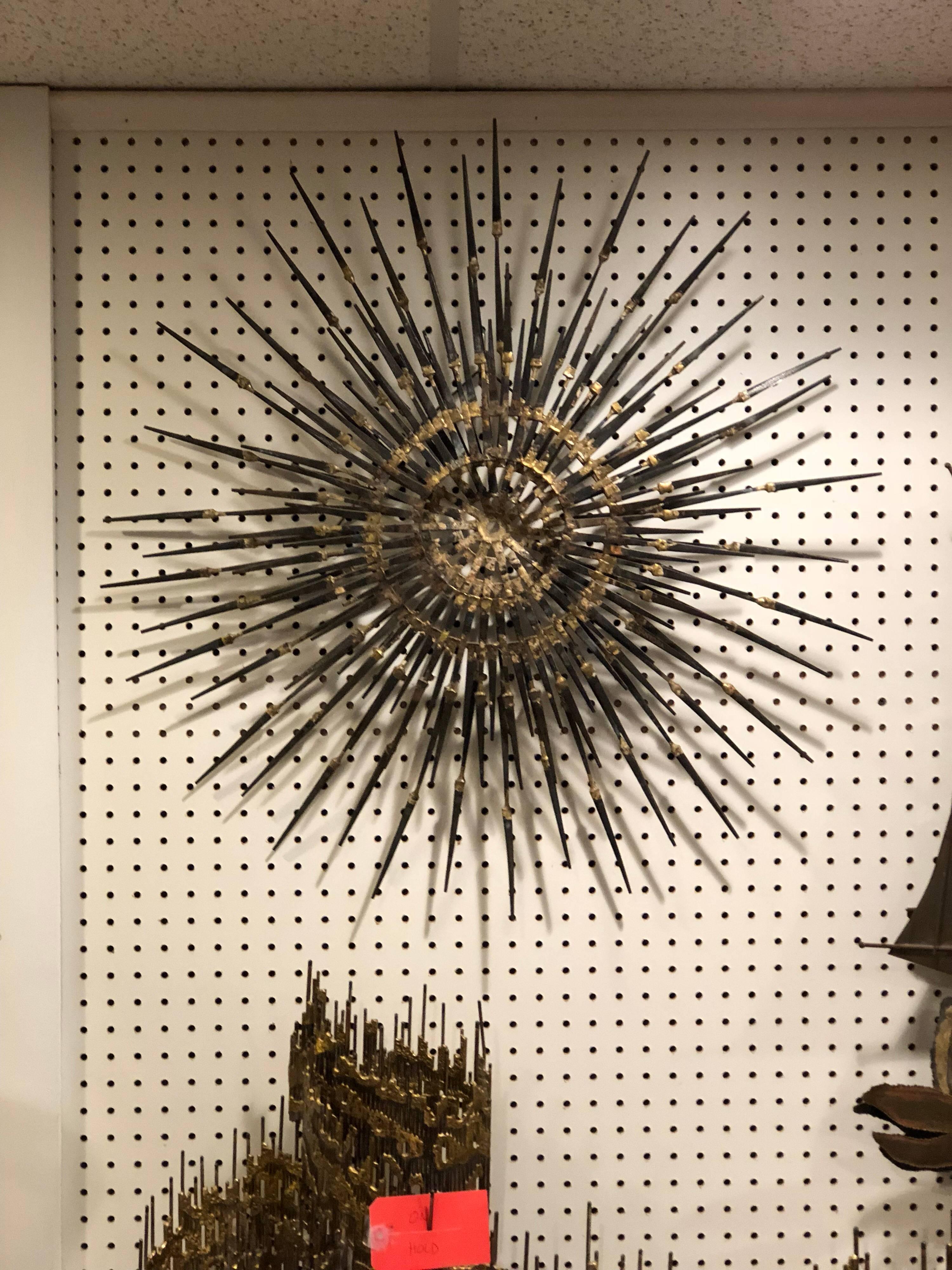 Signed Mid-Century Modern starburst sculpture by Santora. Handmade nail sculpture with gilt accents.
Measures: 30 x 30 x 3 deep. Please request a parcel quote from 1stdibs as it will be cheaper than their white glove quote. This item should ship via