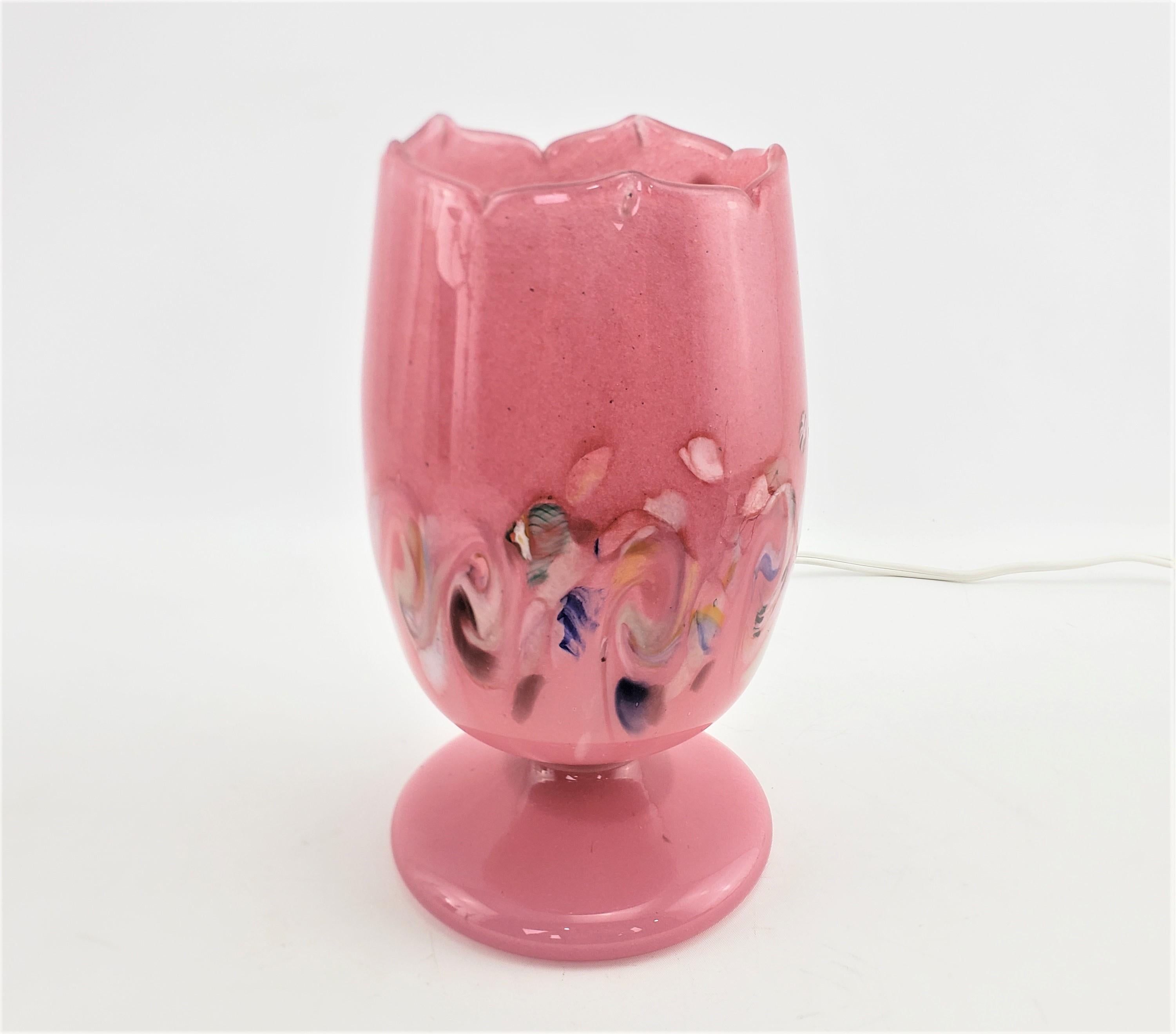 Cette lampe de table ou d'appoint en verre d'art a été fabriquée par la célèbre verrerie écossaise Vasart vers 1969 dans le style moderne du milieu du siècle. La lampe est faite d'un épais fond rose ou canneberge avec un décor de cannelures tirées