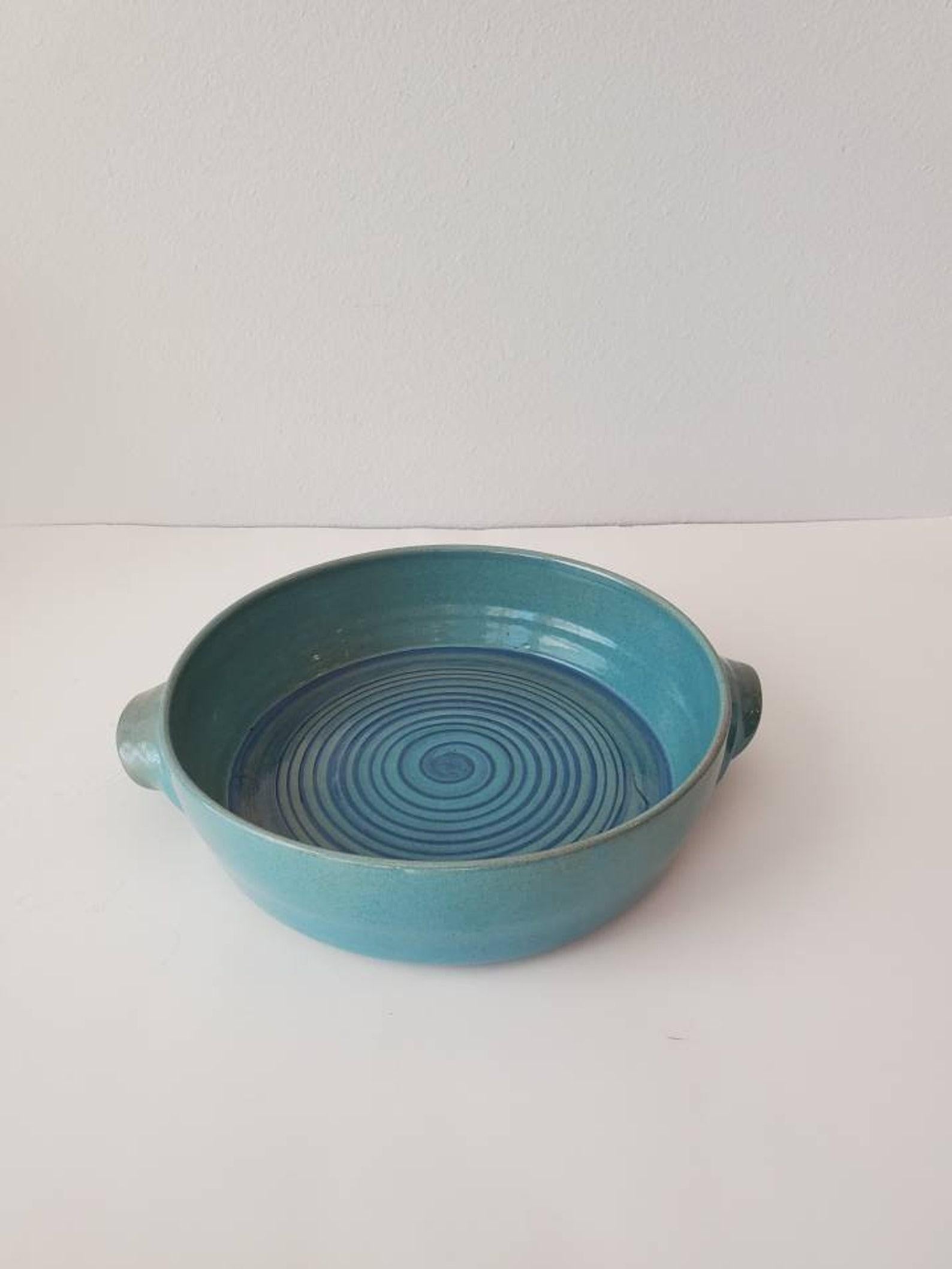 Early and rare hand-thrown ceramic serving dish by mid-century modern masters, Edwin and Mary Scheier. With curved handles and a swirl design, this fabulous hand-crafted pottery stoneware features a circular three inch deep bowl basin, with two