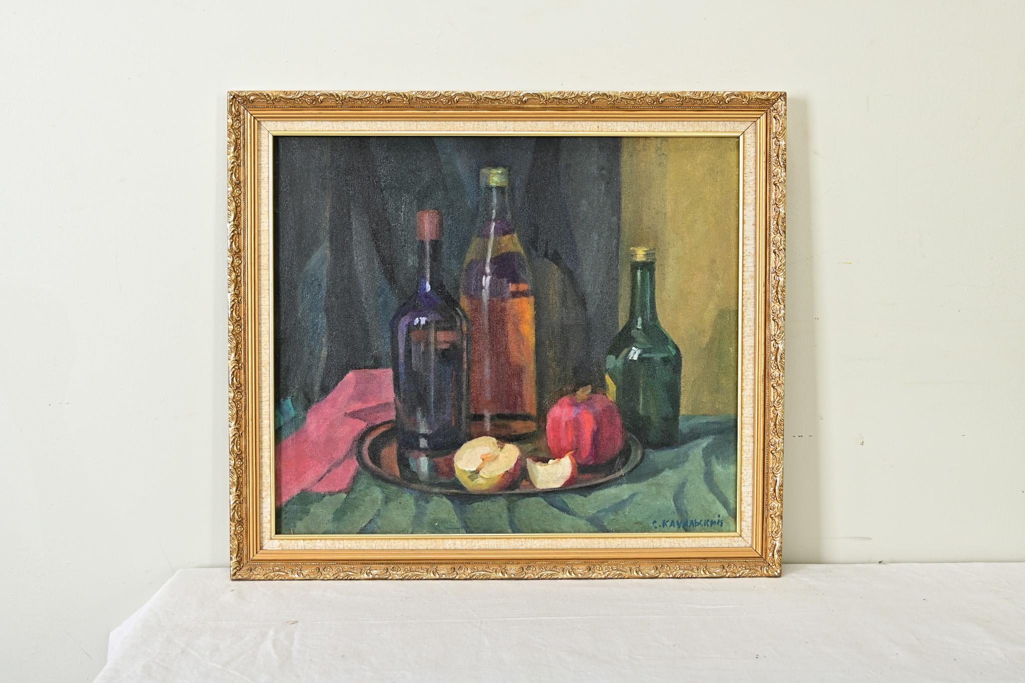 A midcentury modern still-life painting of assorted bottles and fruit on a fabric-draped table, signed by the artist Stanislav Kachalski. The various forms come to life in a rich palette of blue, green, amber, and swathes of pink that give dimension