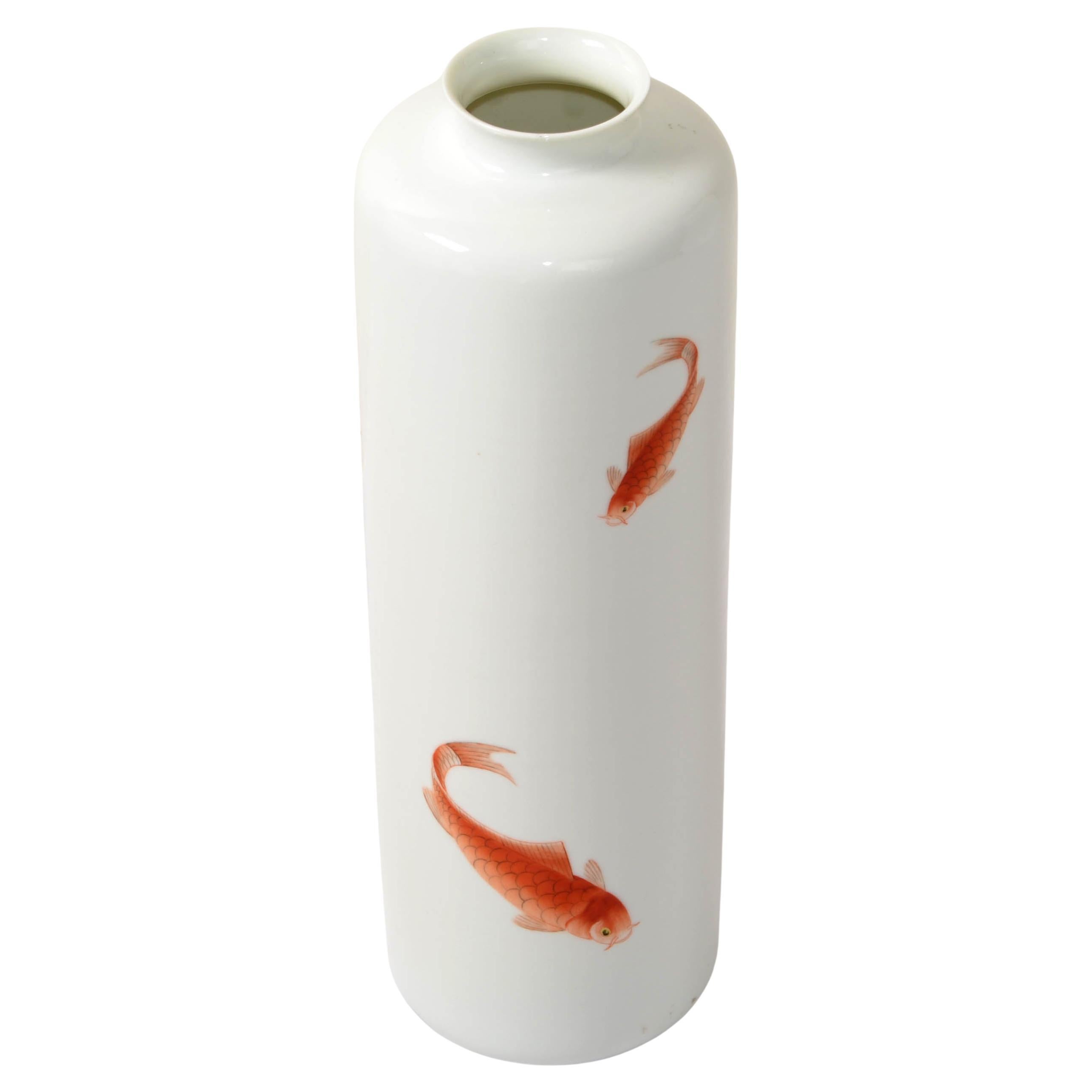 Te ofrecemos un fino jarrón de porcelana fabricado por MK Bo Jia for Middle Kingdom, Japón.
Pintado a mano con revestimiento de pan de oro y representando 2 peces Koi de color rojo hierro con ojos turquesa. 
El Jarrón es del Estilo del Periodo Meiji