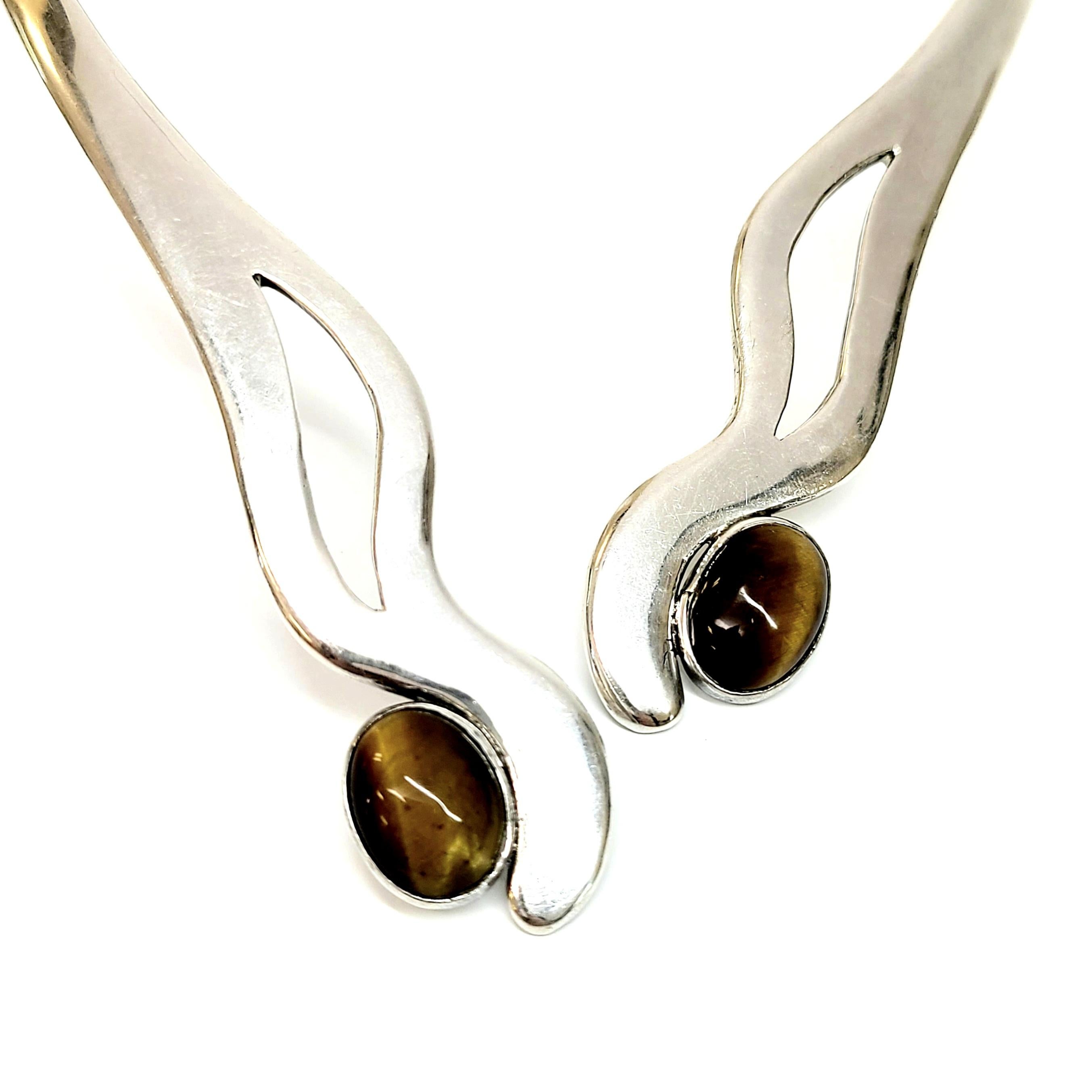 Signed MSA, Mexican sterling silver and tiger's eye clamper necklace.

This beautiful vintage piece, made in Iguala, Mexico, features two oval tiger's eye stones bezel set at the ends of an oblong clamper necklace (hinge at back to open). Designed