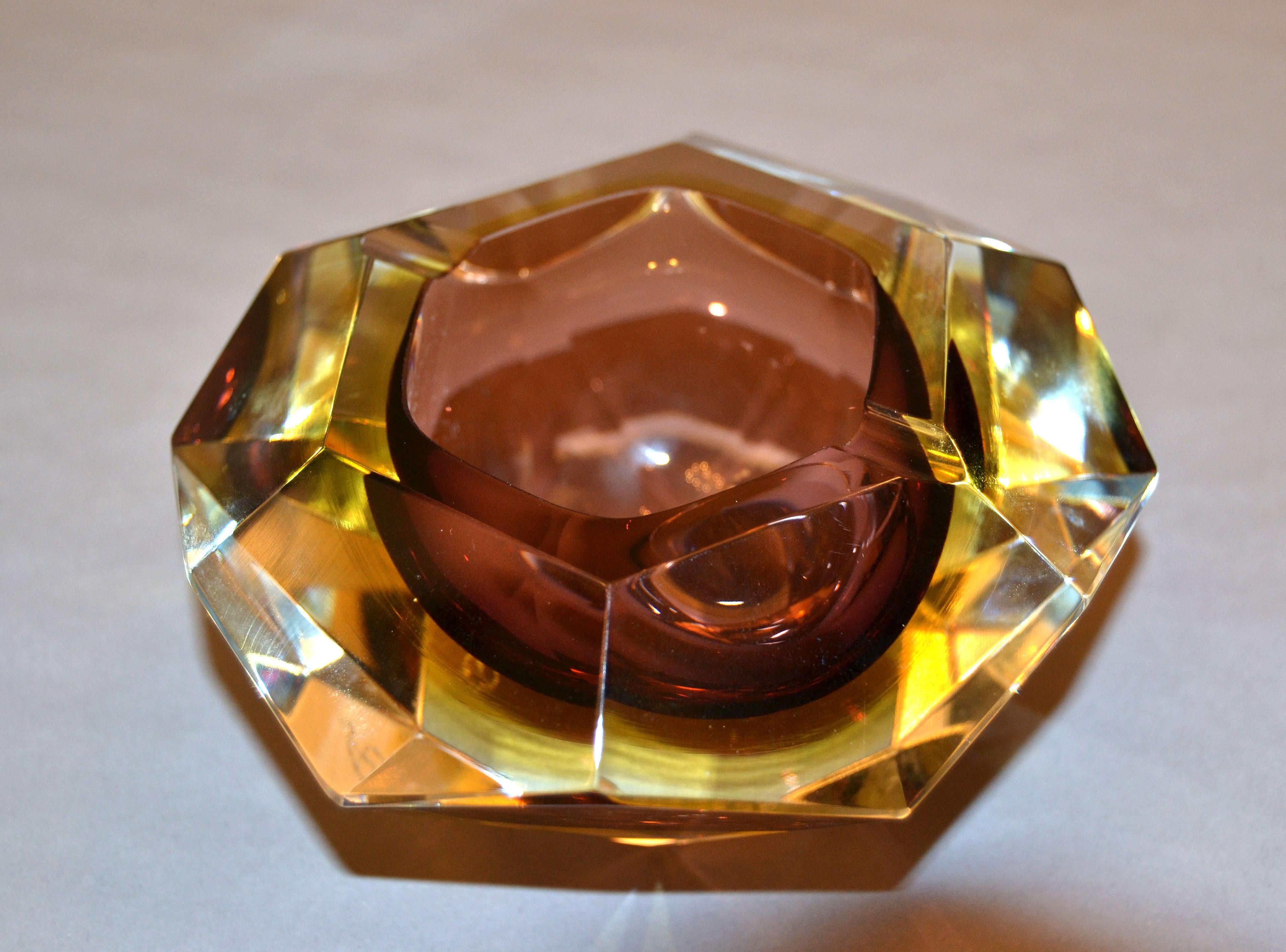 Facettenreicher brauner und gelber Aschenbecher aus Murano-Glas von Sommerso, Glasschale Flavio Poli zugeschrieben.
Braunes und bernsteinfarbenes Glas, eingefasst in klares Glas und ein hochdekoratives geometrisches Muster mit zwölf Flächen.
Unten
