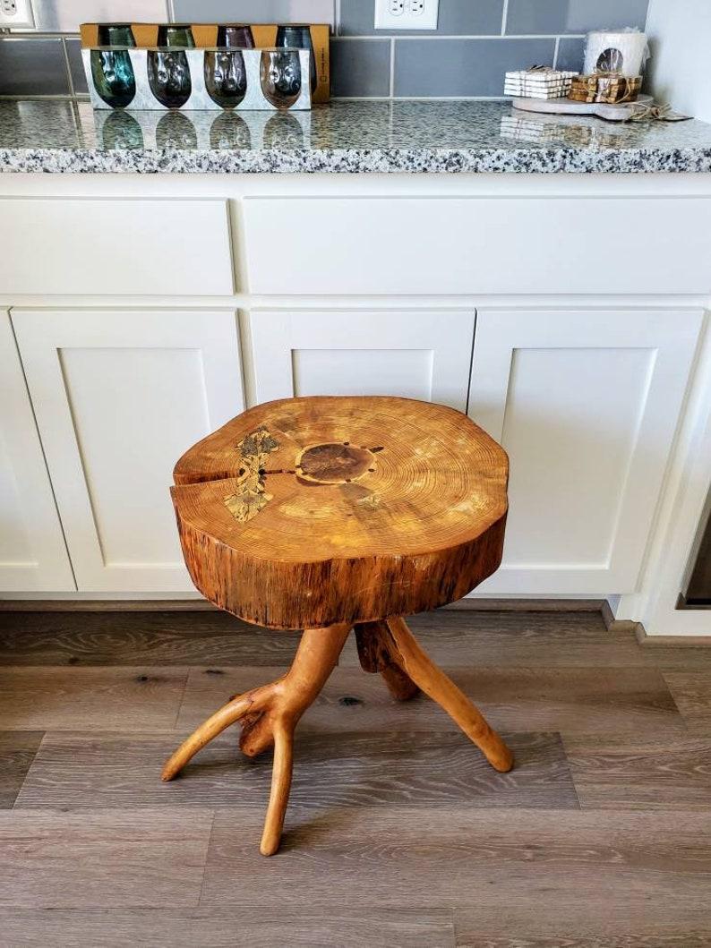 An extraordinary natural live edge slab table, featuring a freeform thick tree trunk slice top, with highly figured wood grain, adding character and interest a split is joined by a large batwing with points shaped tie inlay, exhibiting a finely