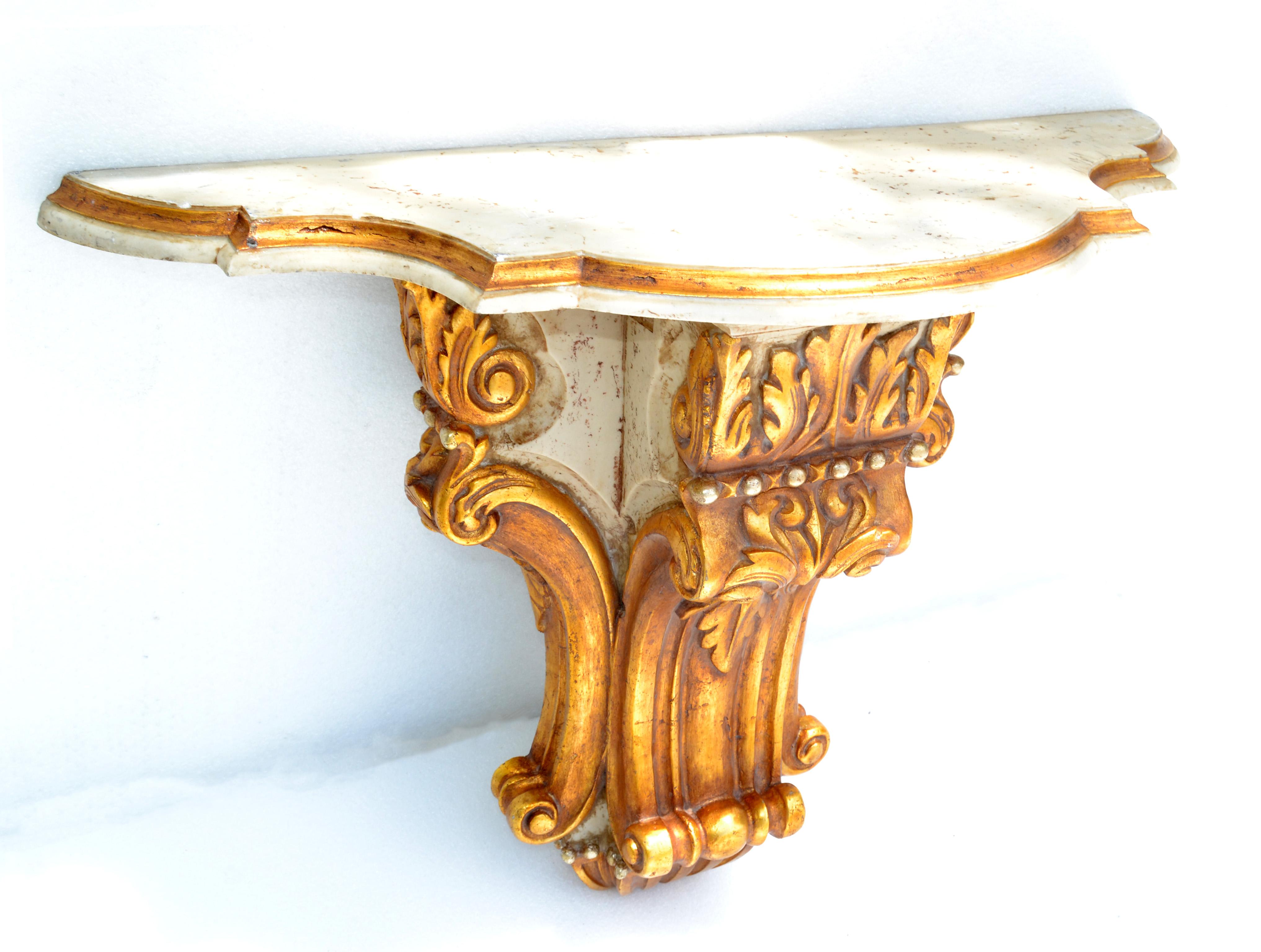 Wall mounted console table or shelf by Orejudo ??? made in Spain in the 1970.
Scrolled and hand carved wall bracket made out of Gilt wood and a Marble Top in taupe color with Gold border.
In original pristine vintage condition with some scratches