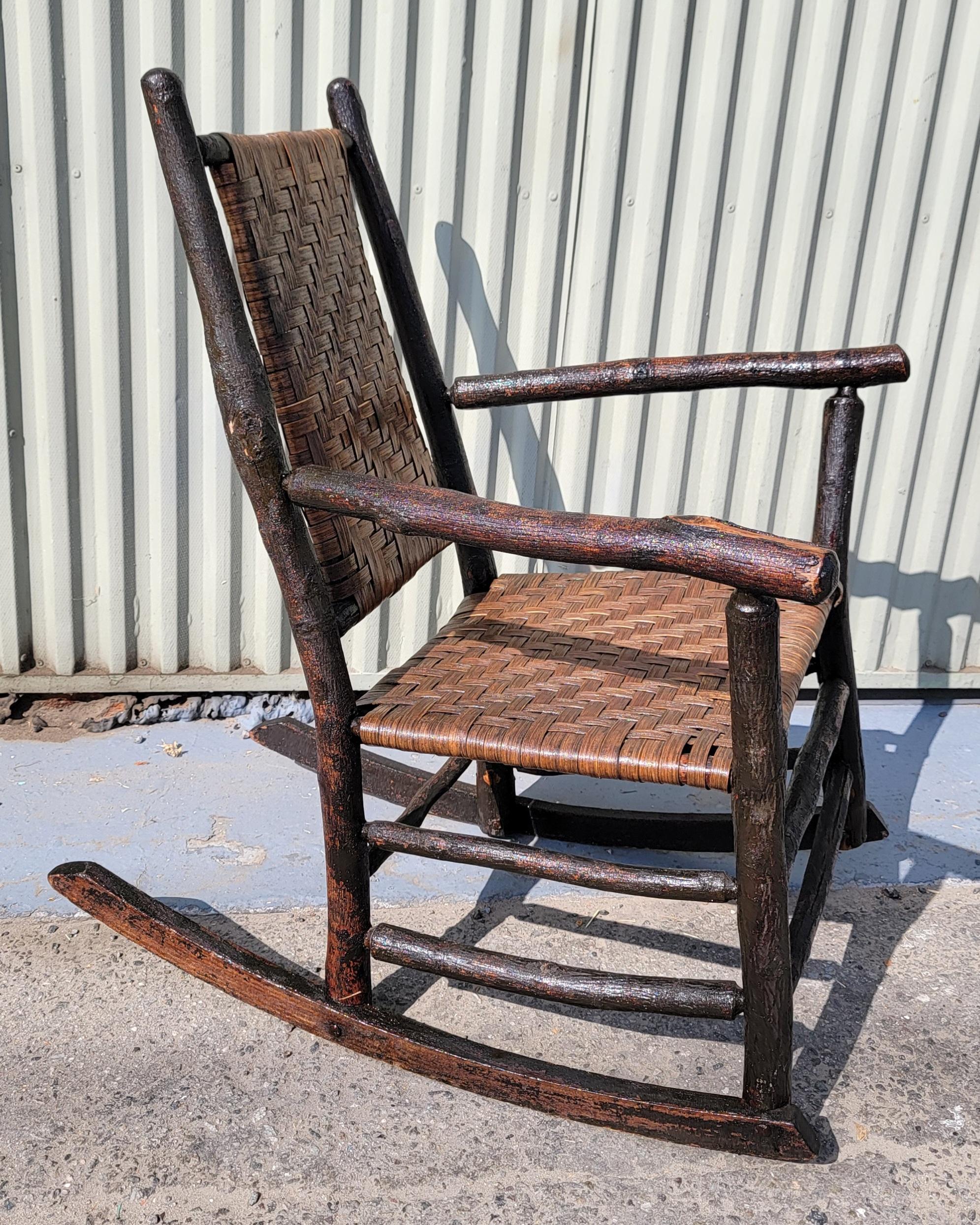 Questa bella sedia a dondolo rustica Old Hickory Furniture Company, proveniente dall'Indiana, è firmata Old Hickory Furniture Company / Martinsville, Indiana. Il dondolo ha la seduta e lo schienale originali intrecciati ed è in ottime condizioni.