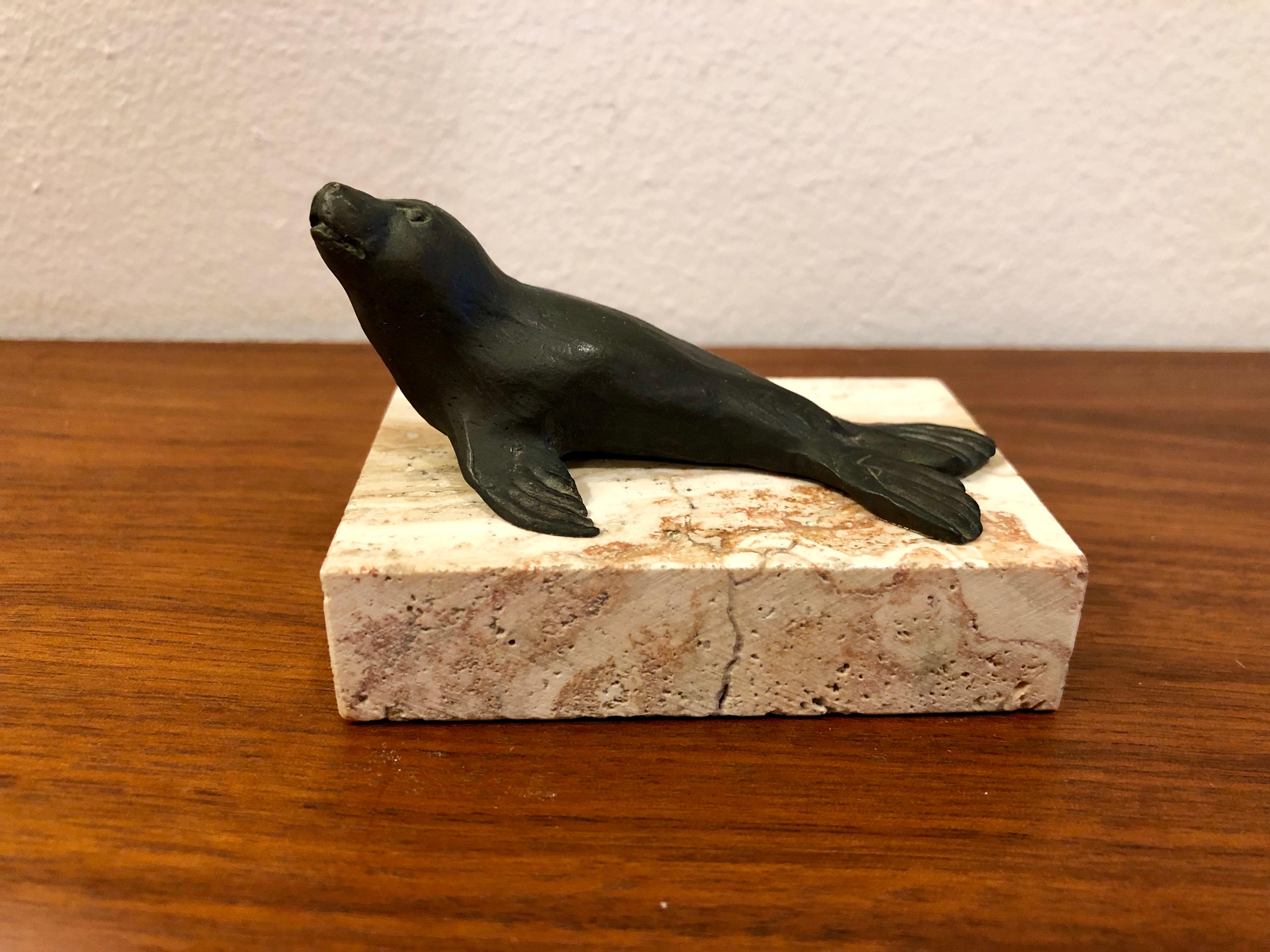 Petite solid bronze original sculpture by listed artist Siggy Puchta, sitting on a travertine base.
