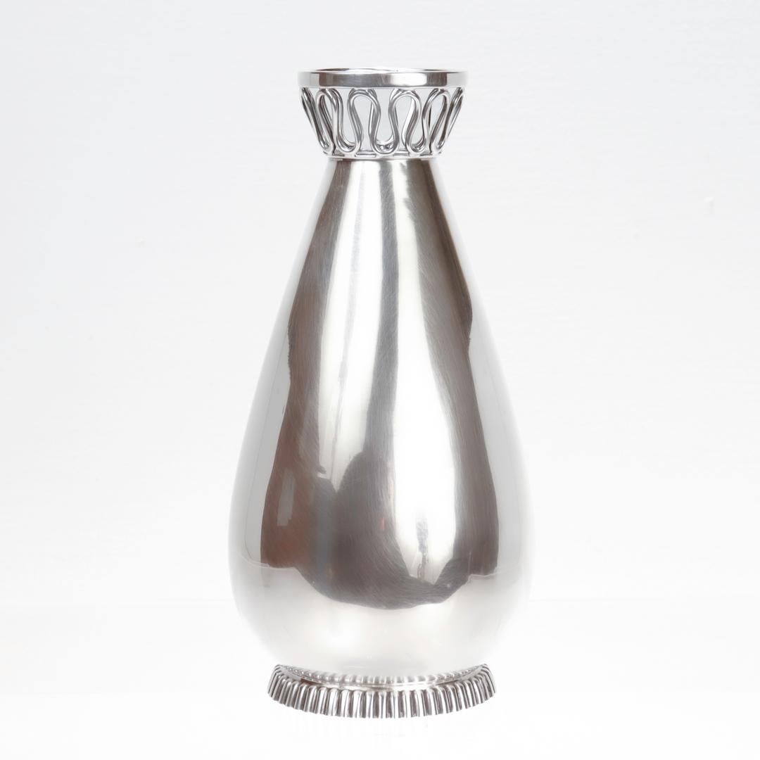 A fine German Modernist flower vase.

In sterling silver.

By the renowned German silvermith, Otto Wolter.

The vase with a wirework neck and a teardrop body supported by an oval scalloped foot.

Fully hallmarked for Otto Wolter to the base.

Simply