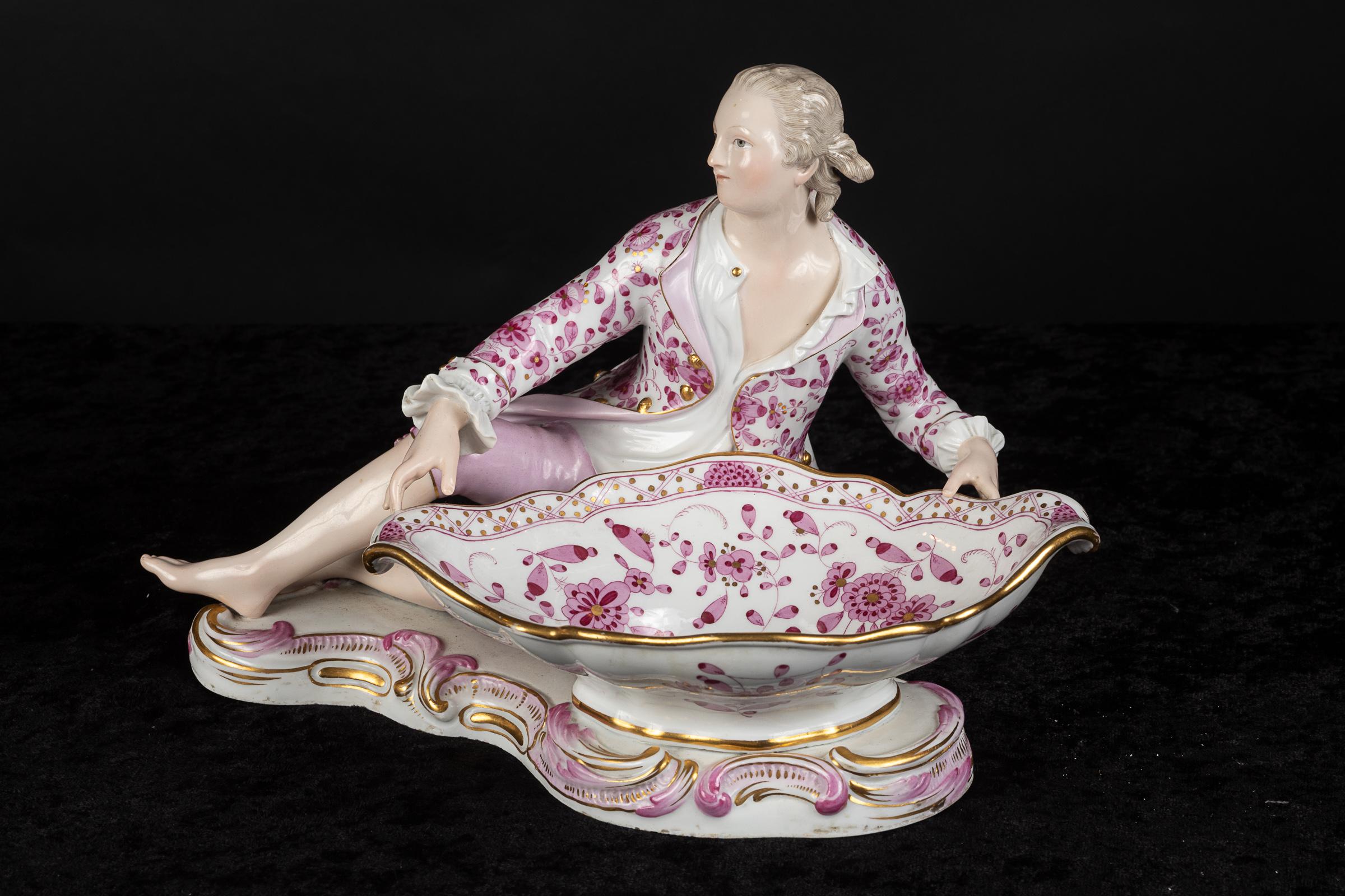 Pair of 19th century Meissen sweet meat dishes: one in the form of a reclining gentleman, the other in the form of a reclining lady with one bare breast – the style of the 18th century.  The sweet meat dishes are exquisitely decorated with rose, and