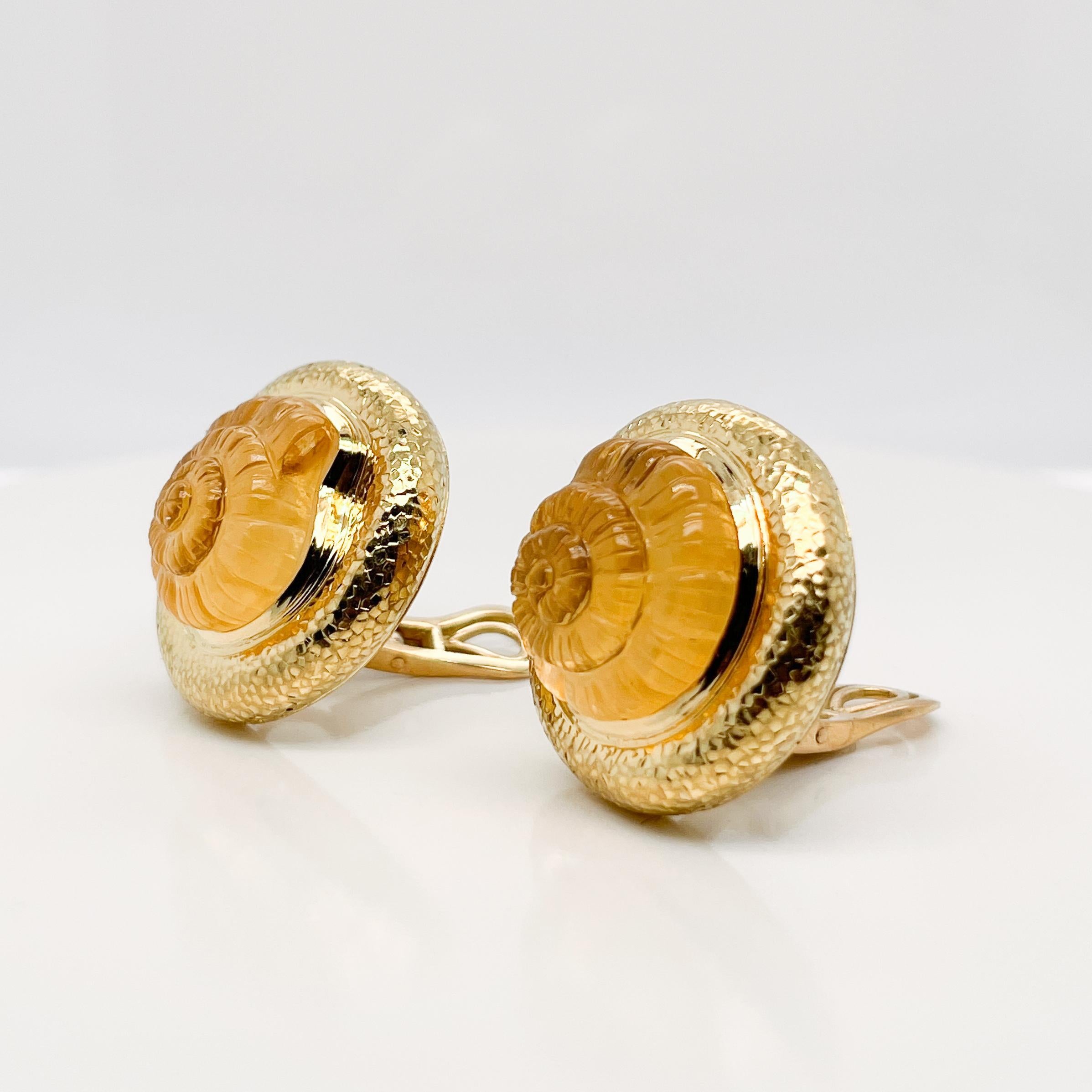 A very fine pair of Elizabeth Gage nautilus earrings.

Each with a carved citrine nautilus set on top of mother of pearl disc and framed in hammered 18k gold.

Simply a great pair of clip-on earrings from one of the world's top jewelry