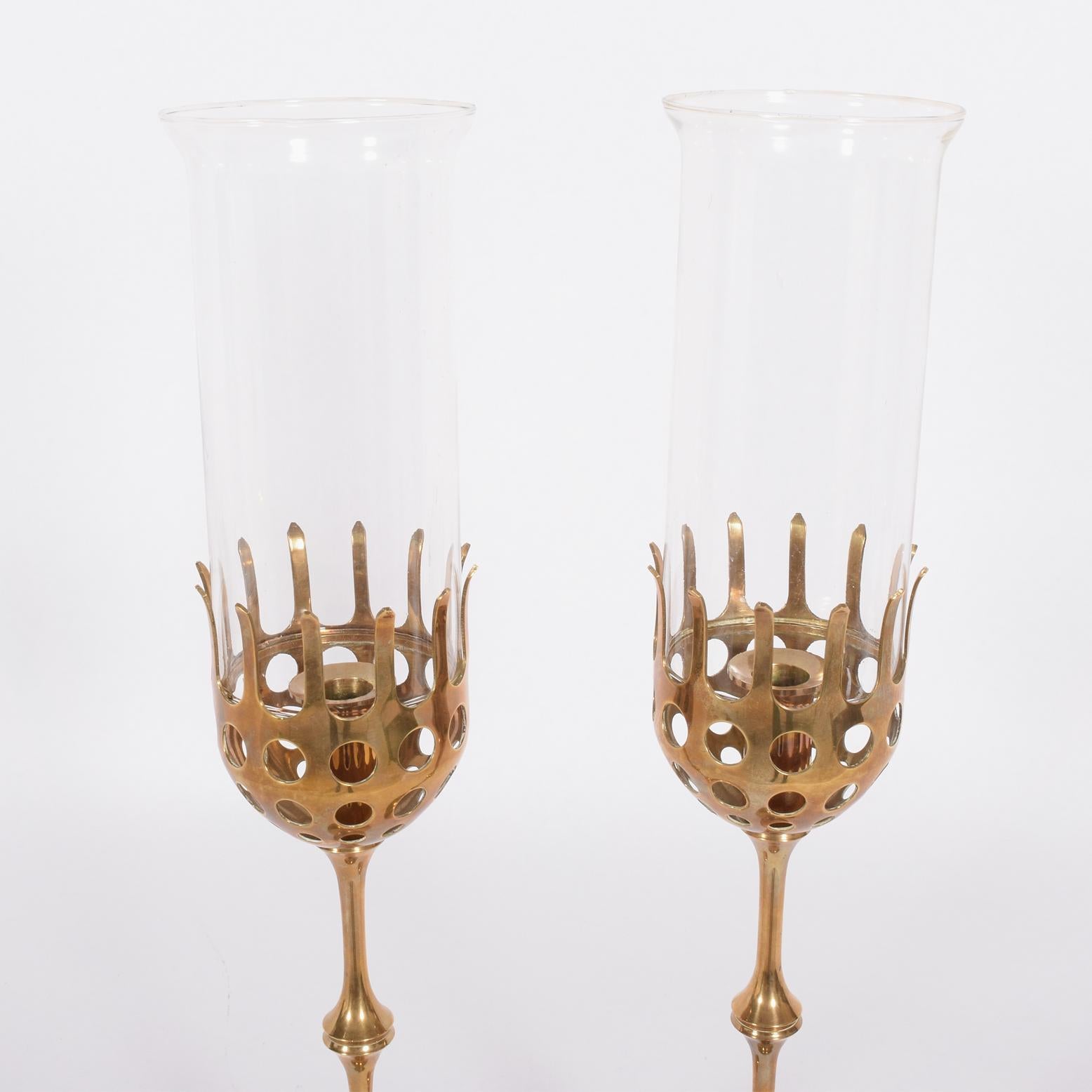 Brass candlesticks with glass shades. Adjustable to shorter height. Made by Bjorn Wiinblad Studio. Signed.
