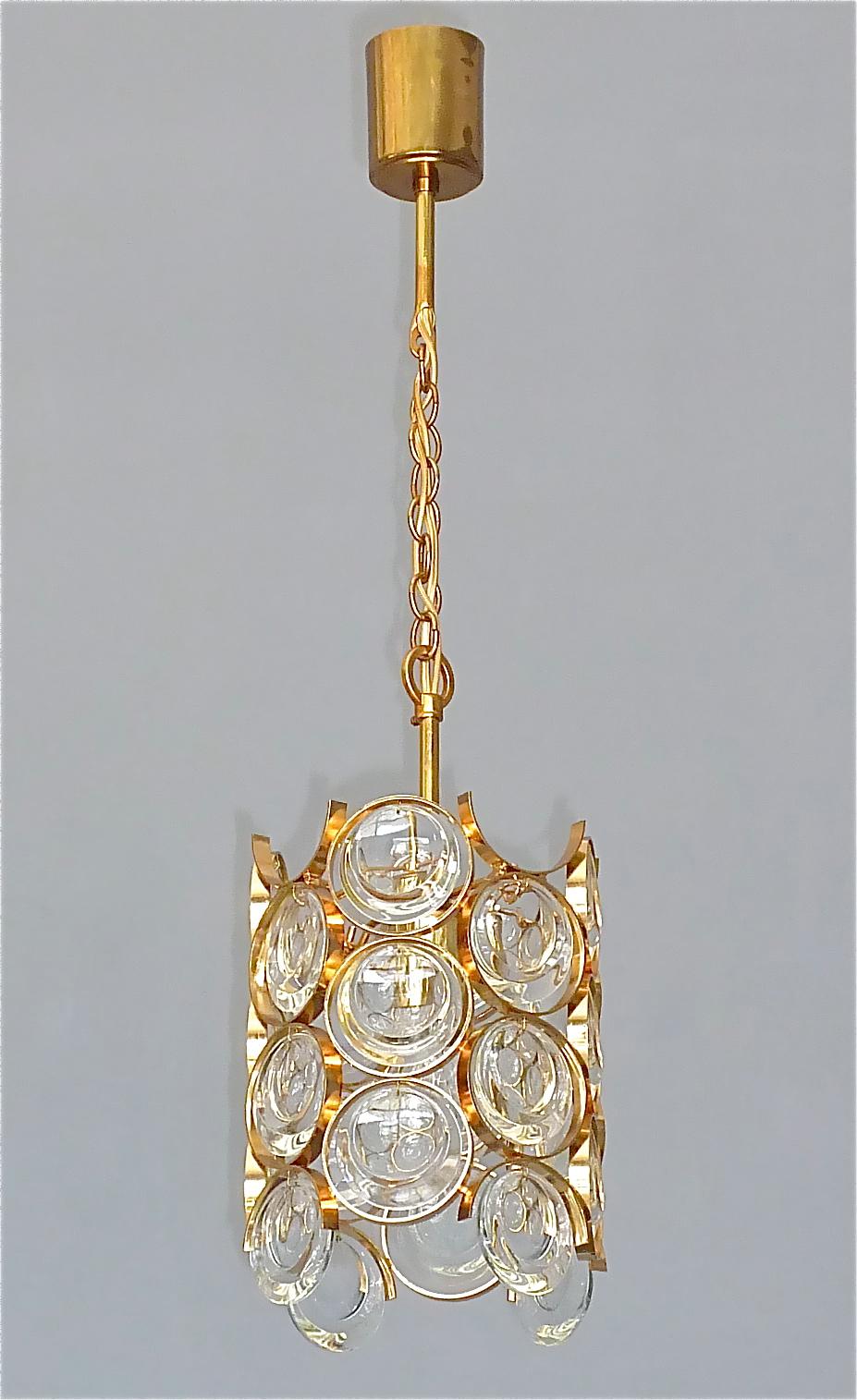 Gilt brass metal and crystal glass chandelier made by Palwa, Germany circa 1960-1970. The chain-hanging length-adjustable pendant lamp has a gilt brass metal construction in Op Art Pop Art Look with beveled crystals glass discs within rings and is
