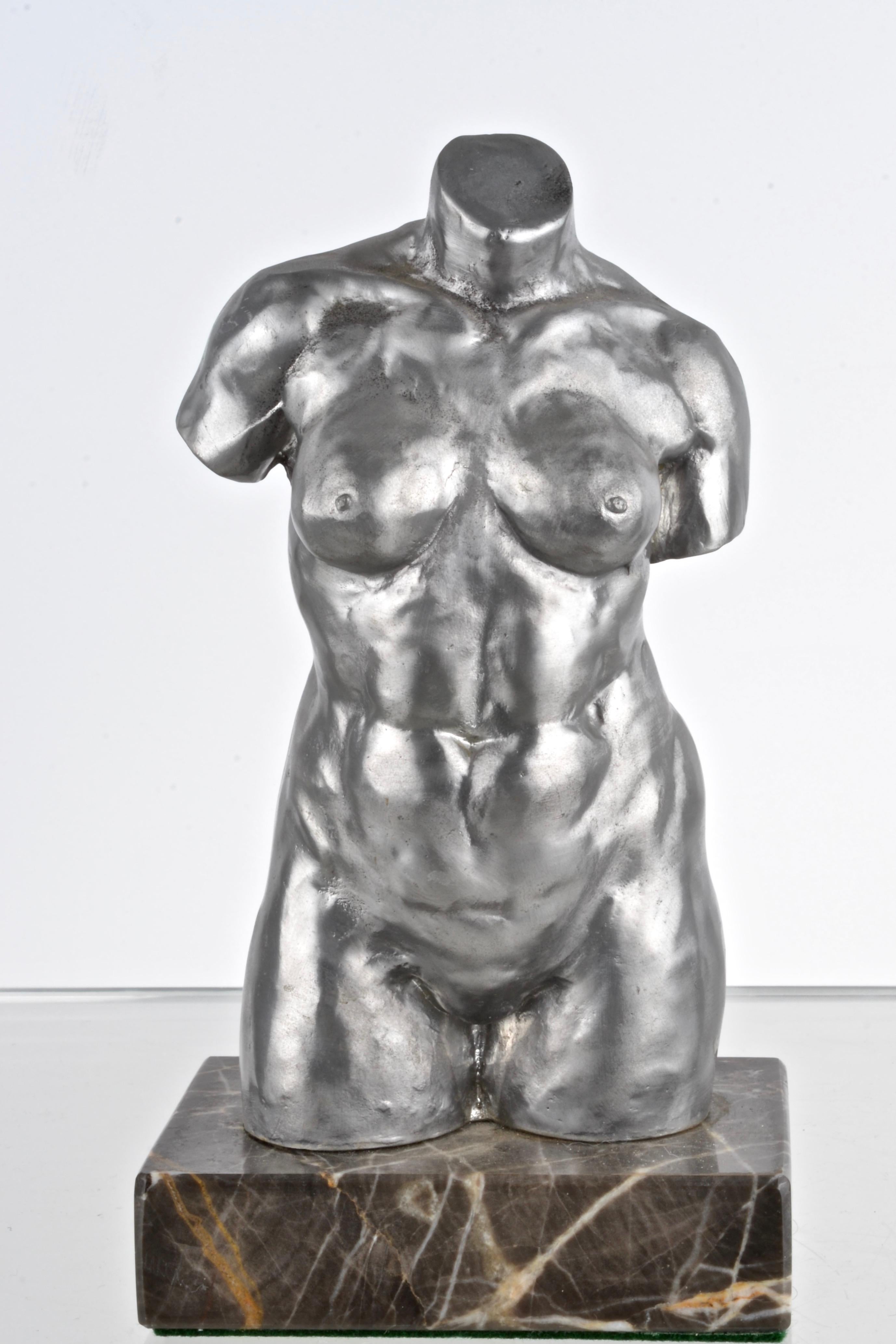 A finely cast female torso in pewter mounted on a marble base. Signed A.H.E.T. and RF Pewter.