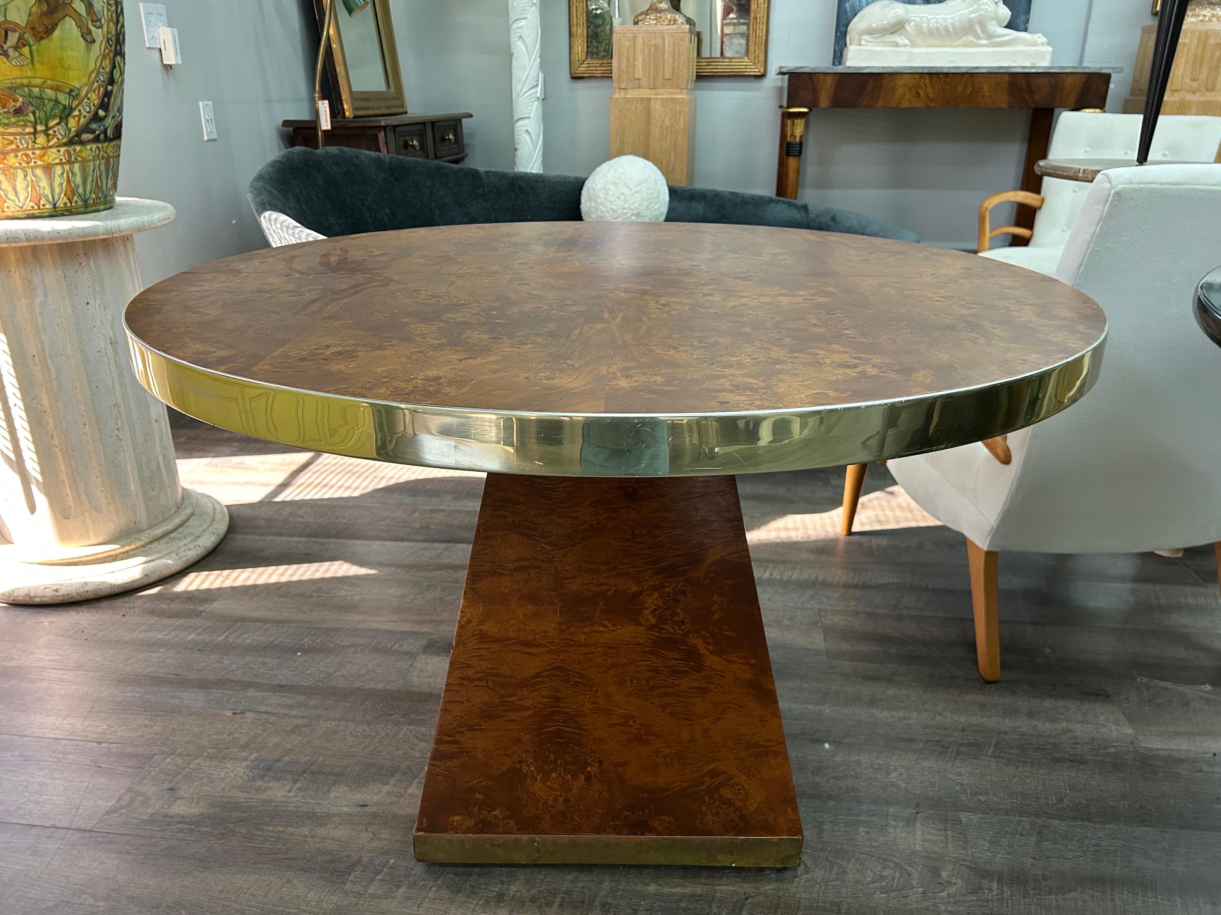 Table signée Pierre Cardin en bronze et laiton. 
Nous vous proposons une belle table centrale, table de salle à manger ou table de jeu ronde en bois d'olivier ronce mat et laiton, signée Pierre Cardin.
La signature se trouve sur la bande autour de