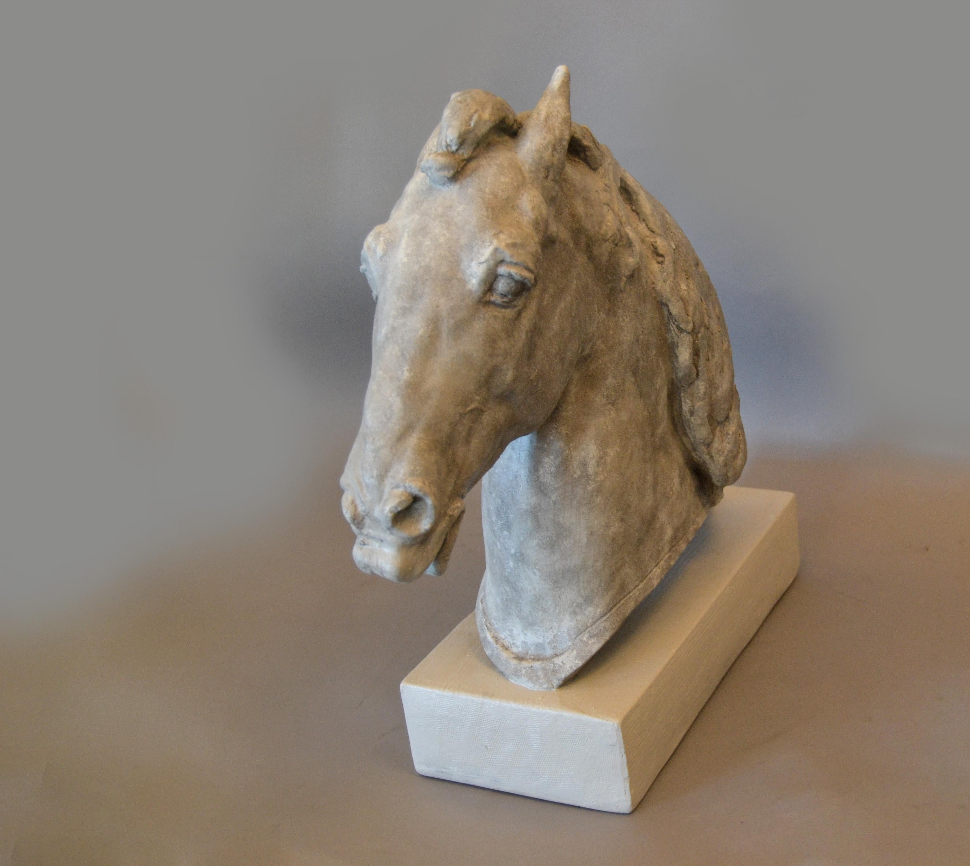 Graceful Mid-Century Modern plaster horse head sculpture on a wooden base.
The horse head has a grey finish and is attached to the white base.
It is signed and dated at the base, '1961 A. Lava'.