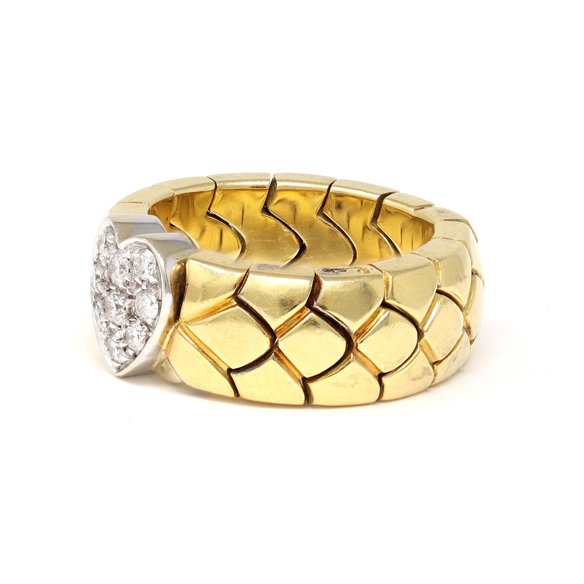 A semi-flexible duo-tone band ring signed by the famous house of Jewelry Pomellato. It features an 18-karat yellow gold flexible link and a diamond heart atop set in 18-karat white gold. The diamonds have 0.20 carats, GH color, and VS clarity. It