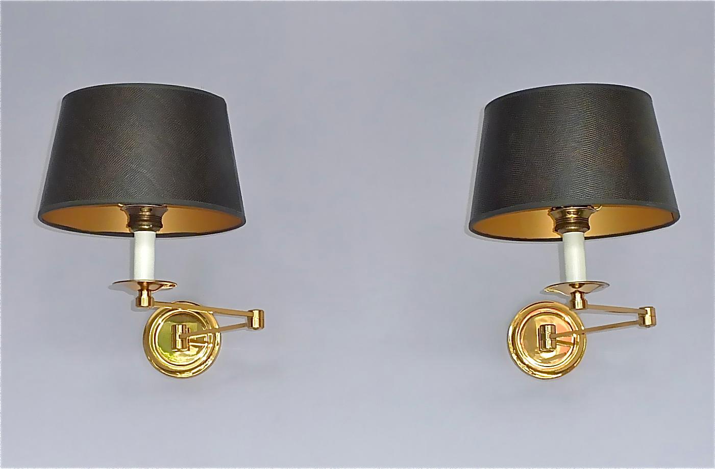 Exclusive rare pair of gilt brass Maison Bagues swing arm sconces, Paris, France circa 1960s to 1970s. The beautiful sconces are documented in the sales catalog and additionally one sconce is signed on reverse of one backplate with the Bagues Paris