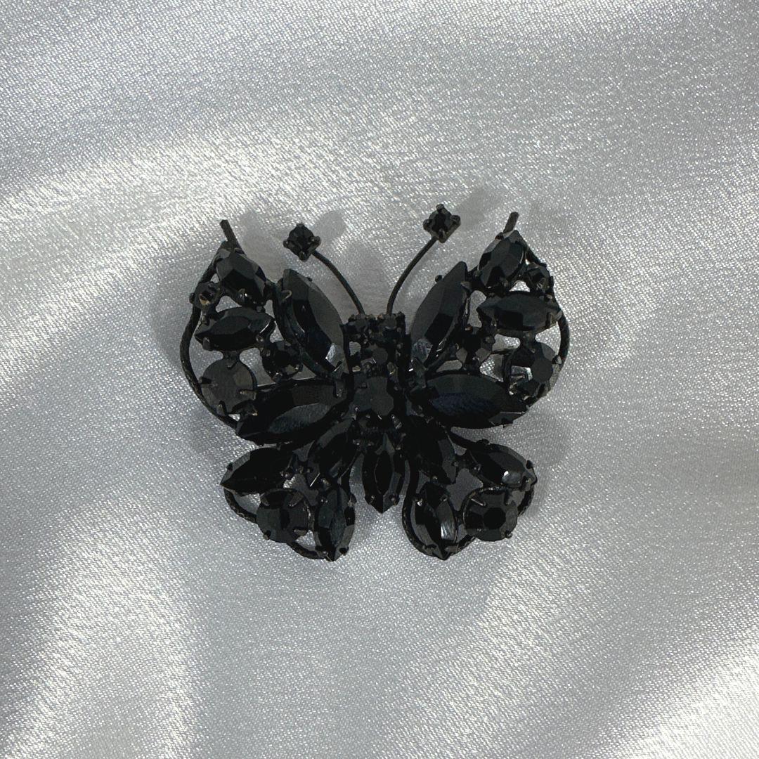 Elevate your style with this exquisite Signed Regency Vintage Black Butterfly Brooch/Pin. Crafted with precision and attention to detail, this stunning piece showcases a timeless design. The delicate butterfly silhouette adds a touch of grace and