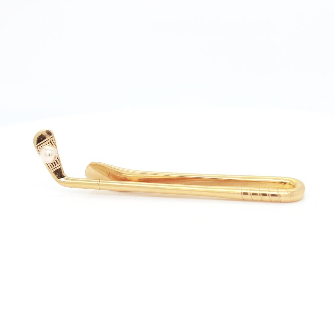 A fine vintage gold tie bar.

By Ballou & Co. Inc. of Providence, RI.

In 14 karat yellow gold.

In the form of a gold club and ball.

Marked to the reverse with B.A.B. (Ballou's maker's mark) / 14K.

Simply a wonderful retro golfing