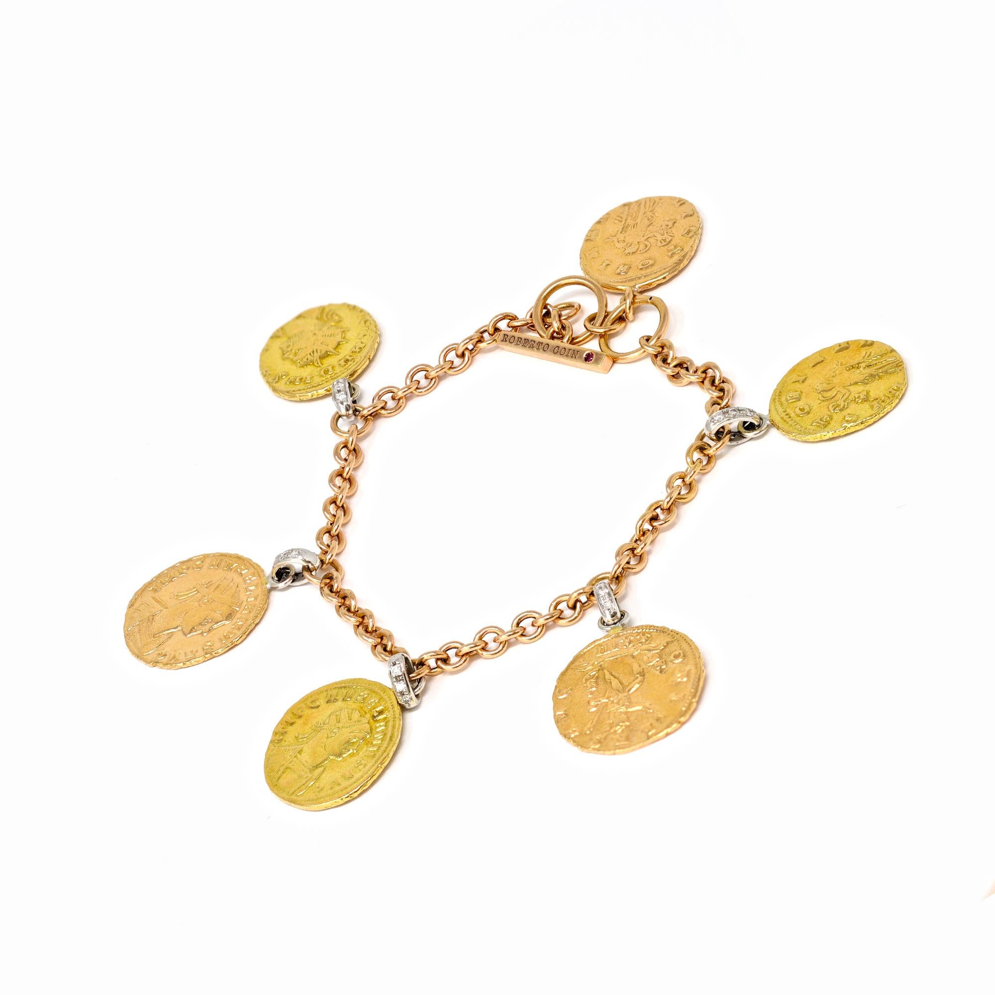 A charm bracelet signed by Roberto Coin, made in Italy circa 1990 featuring tri-tone gold, diamonds and dangling charms in the style of Ancient Roman coins. The bracelet has a toggle clasp and has an estimated weight of 0.60 carats of diamonds GH