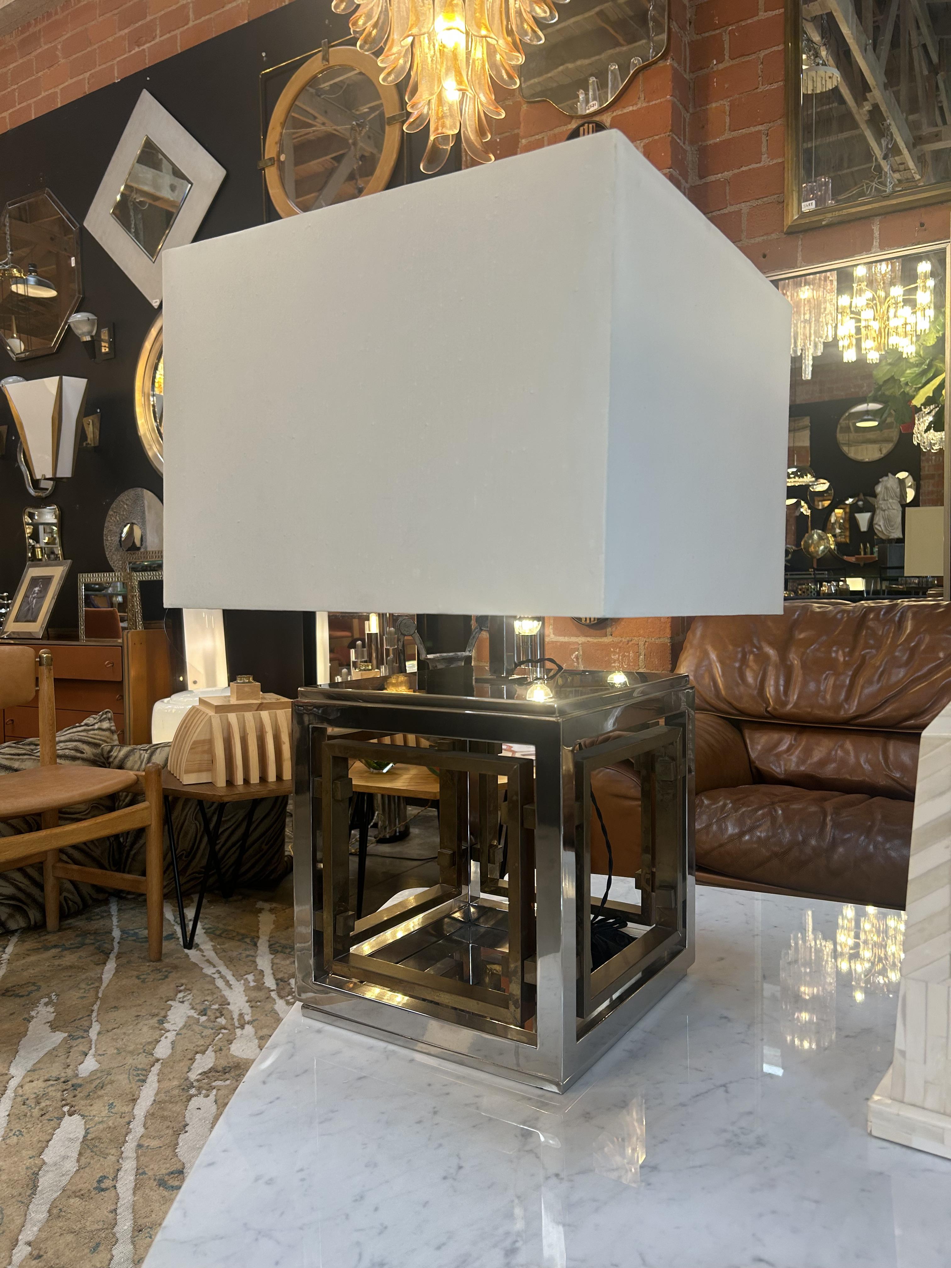 Striking table lamp by renowned Italian designer Romeo Rega from the 1970s, showcasing his signature blend of modernist geometry and glamorous materials. Made in Italy, the lamp features a bold cubic base crafted in polished chrome and brass. The