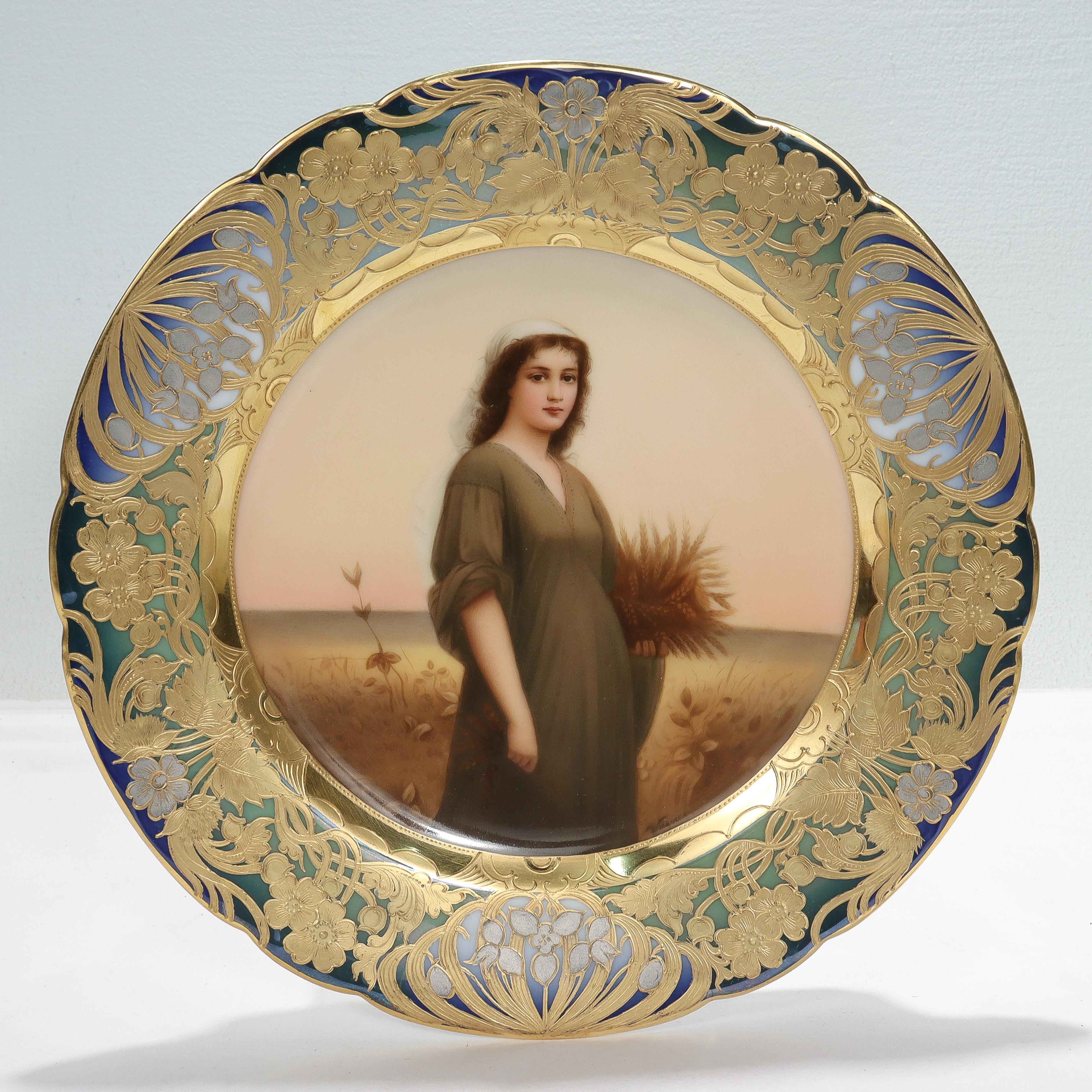 A fine, signed Art Nouveau porcelain cabinet plate.

By Royal Vienna.

Signed Wagner to the lower right.

With a hand painted depiction of Ruth to the center surrounded by a blue & green border richly decorated with platinum, raised gold, &